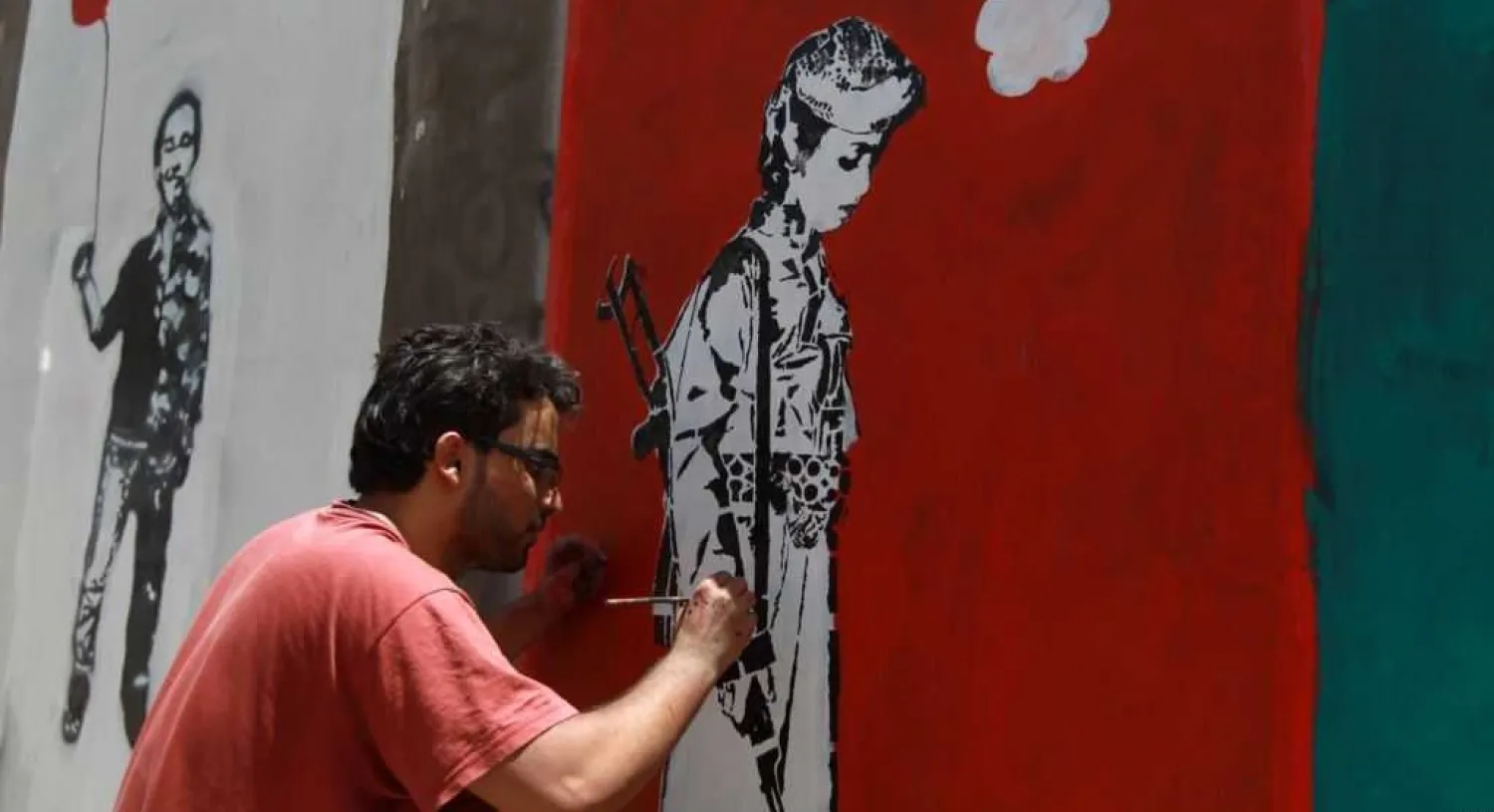 A Yemeni artist works on a mural as part of a campaign to end the recruitment of child soldiers by tribal militias in the capital Sana'a, April 10, 2014 (AFP)
