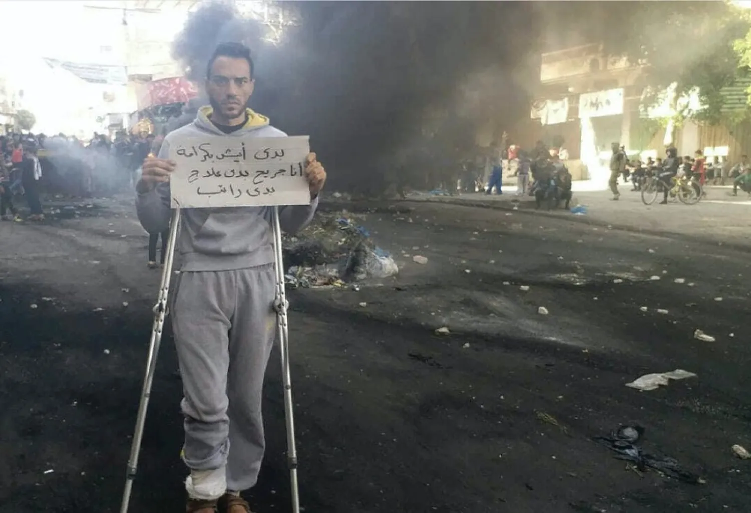 A protester holds a sign that reads, ‘I want to live in dignity; I'm wounded and need treatment and a salary,’ during a protest in central Gaza last week. (Osama al-Kahlout via AP)