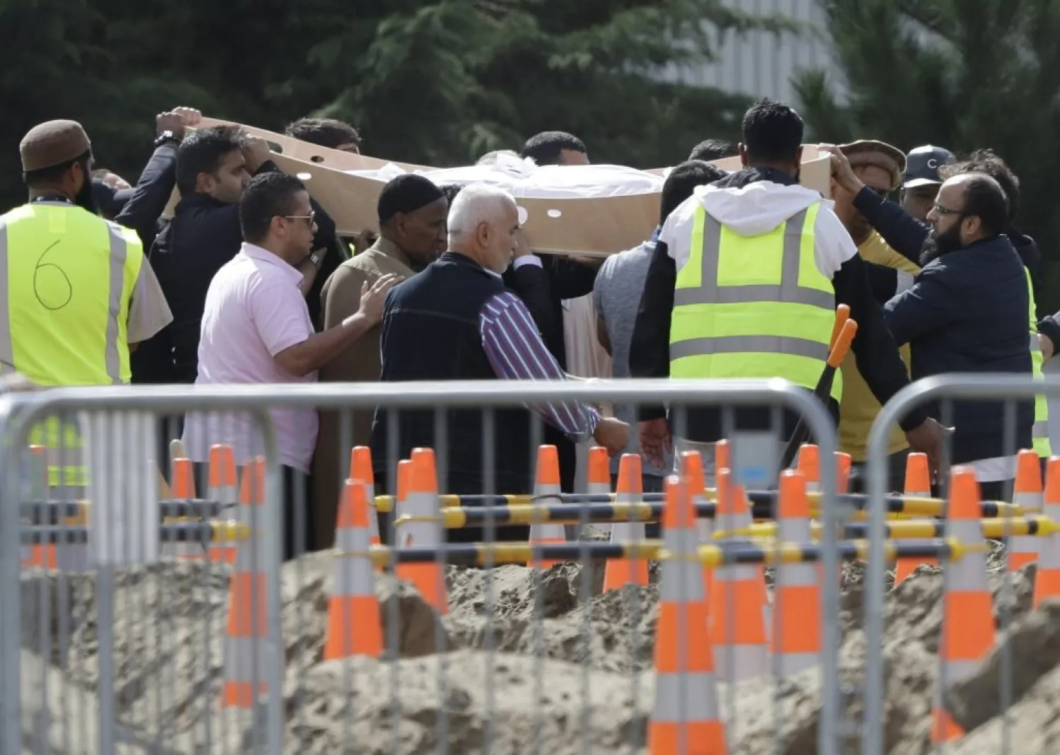 Mourners carry the body of a victim of the Friday March 15 mosque shootings for a burial at the Memorial Park Cemetery in Christchurch, New Zealand, Wednesday, March 20, 2019. (AP Photo/Mark Baker)