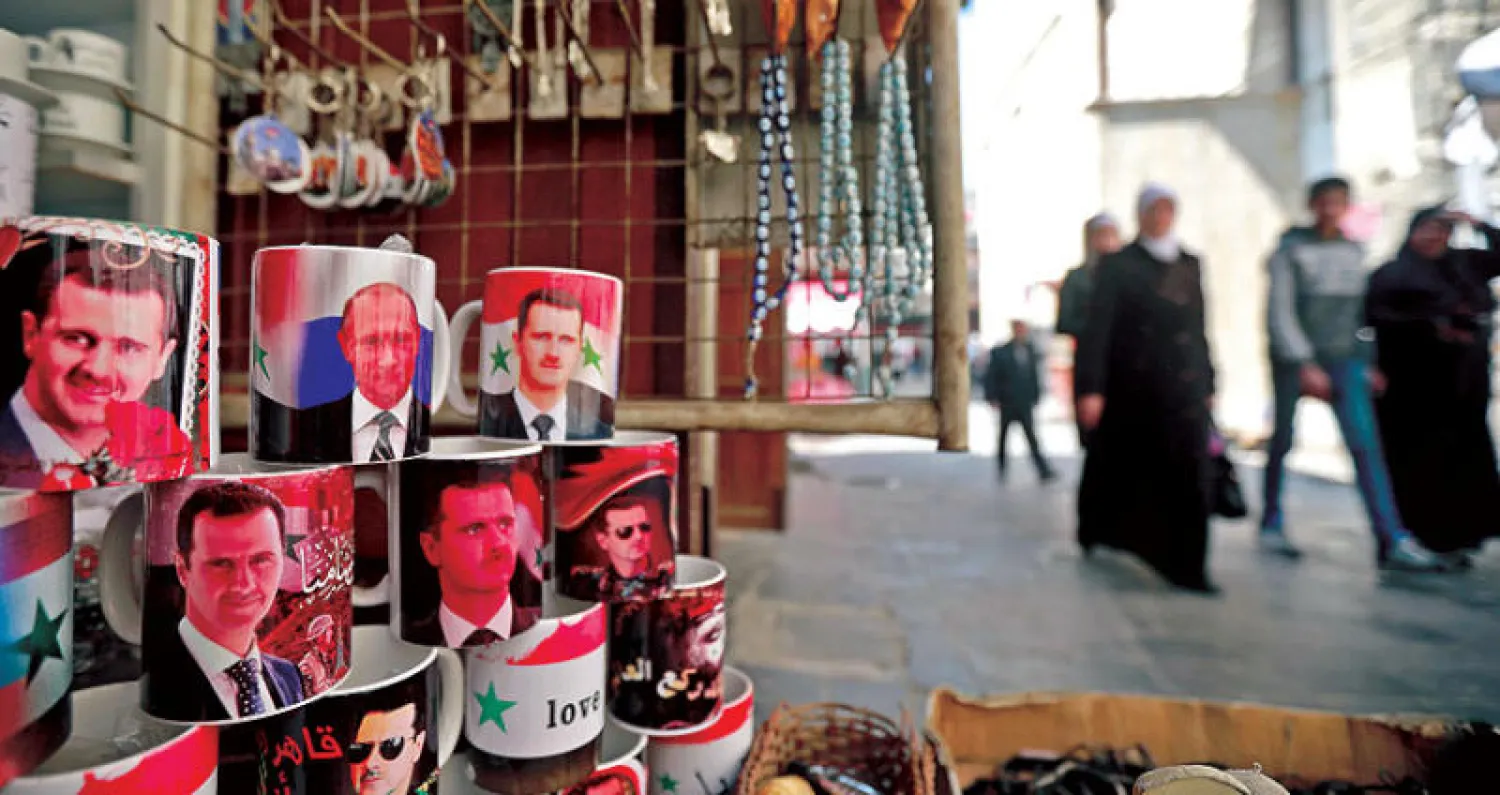 صور بوتين والأسد في سوق الحميدية وسط دمشق (أ.ف.ب)