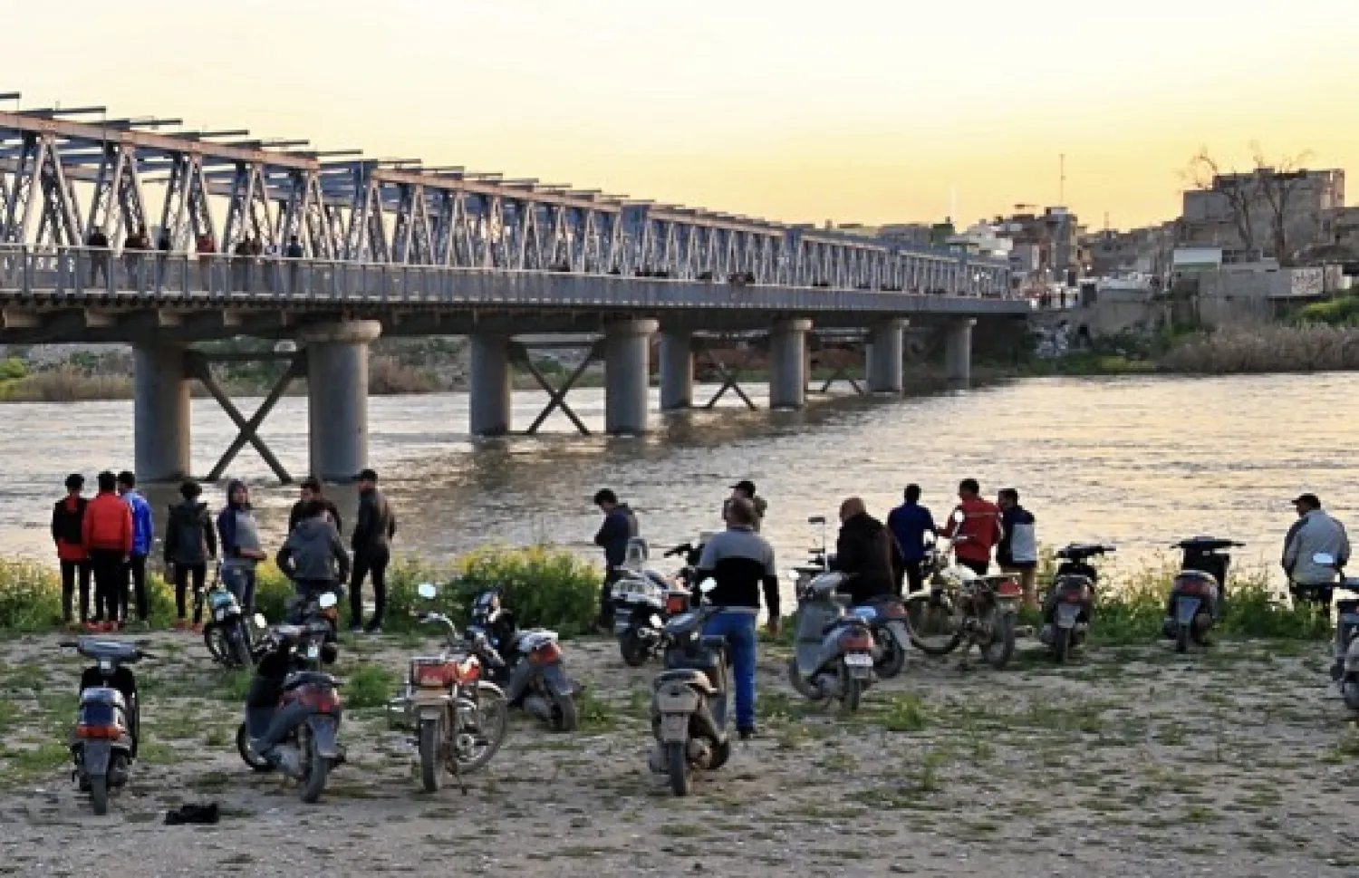 People and relatives of victims waiting on the bank of the Tigris river where the ferry sank in Mosul, Iraq, Thursday, March 21, 2019. (AP Photo/Farid Abdulwahed)