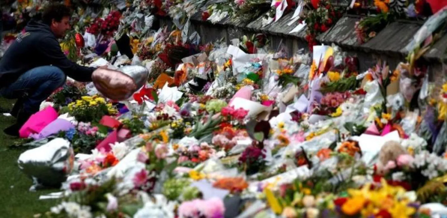 رجل يضع أزهاراً في مكان سقوط ضحايا الهجوم (رويترز)