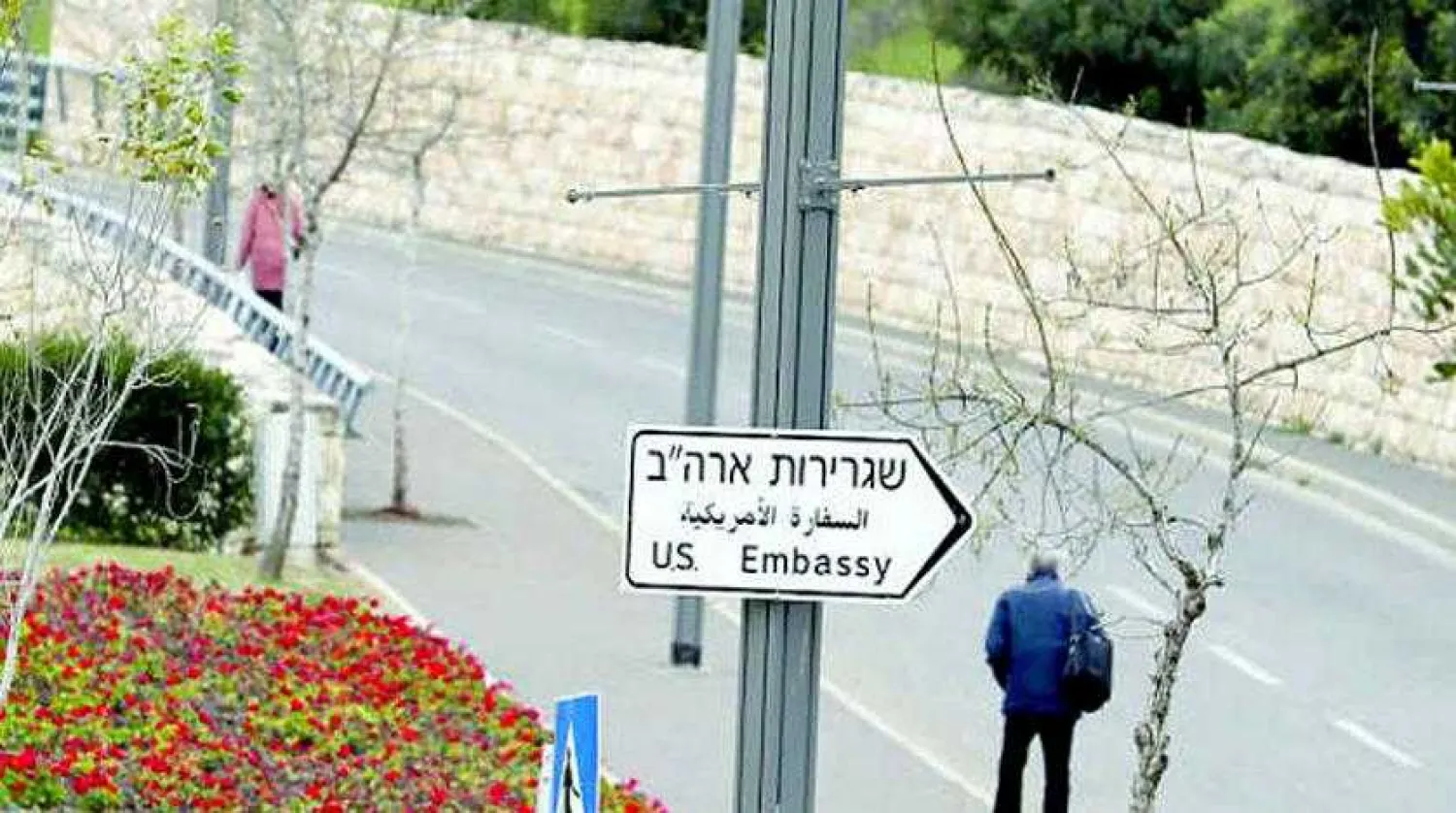 A man walks next to a road sign directing to the US embassy in Jerusalem, February 18, 2019. Picture taken February 18, 2019 REUTERS/Ammar Awad