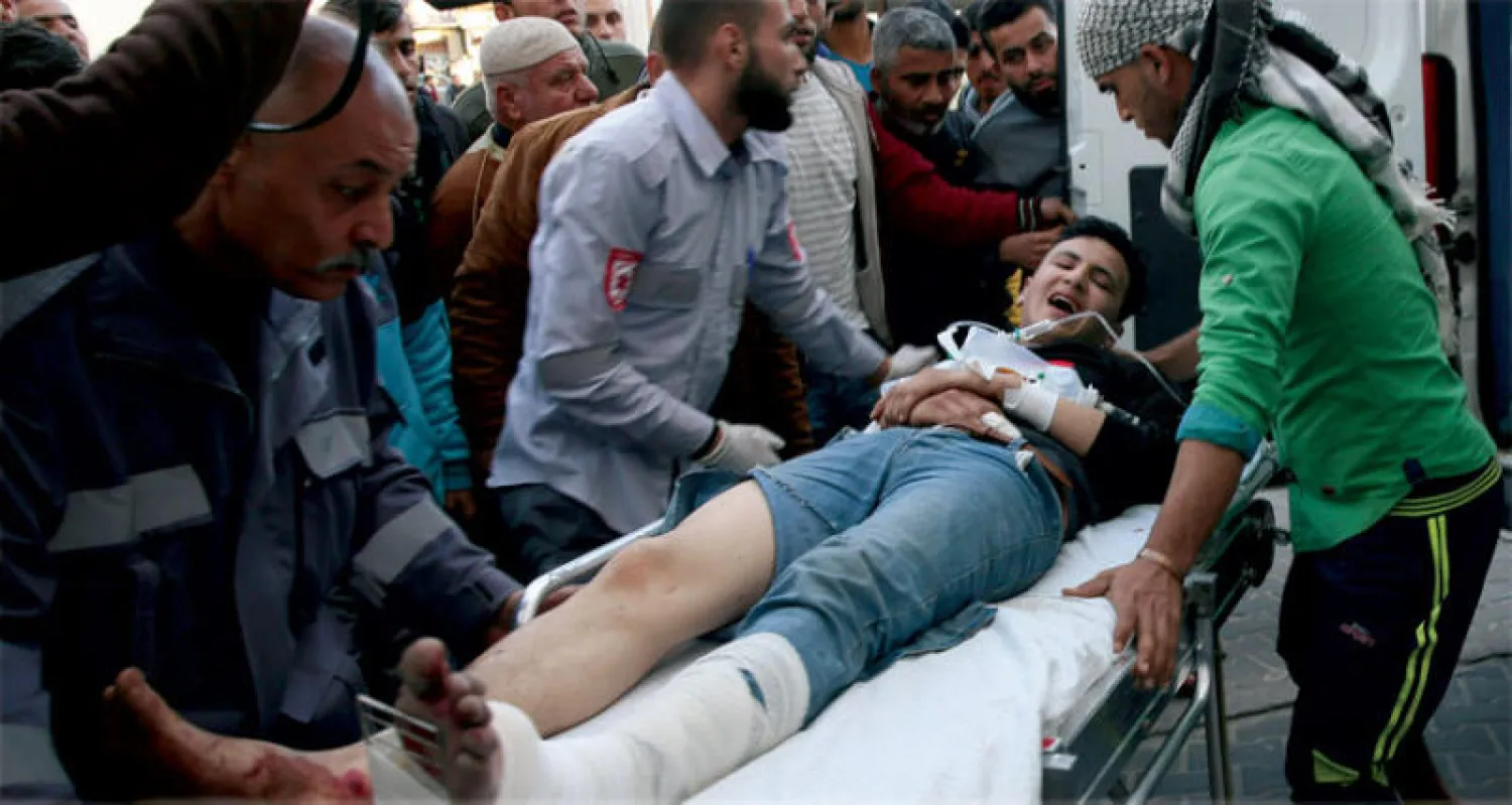 فلسطيني يتلقى العلاج بعد اصابته في اشتباك مع القوات الإسرائيلية على حدود غزة أمس (أ.ب)