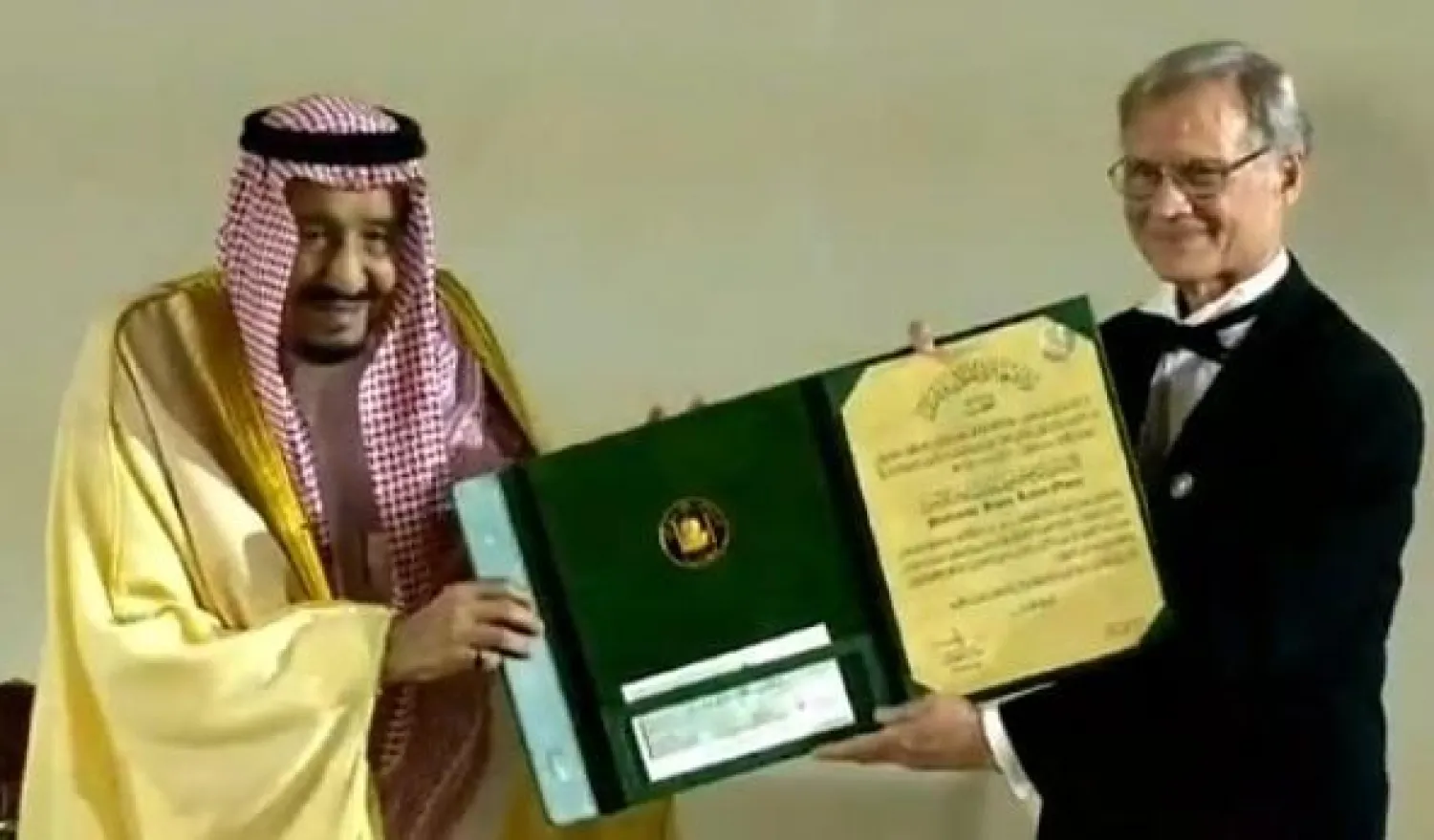 خادم الحرمين الشريفين الملك سلمان بن عبد العزيز يُكرّم أحد الفائزين بجائزة الملك فيصل العالمية (الإخبارية السعودية)