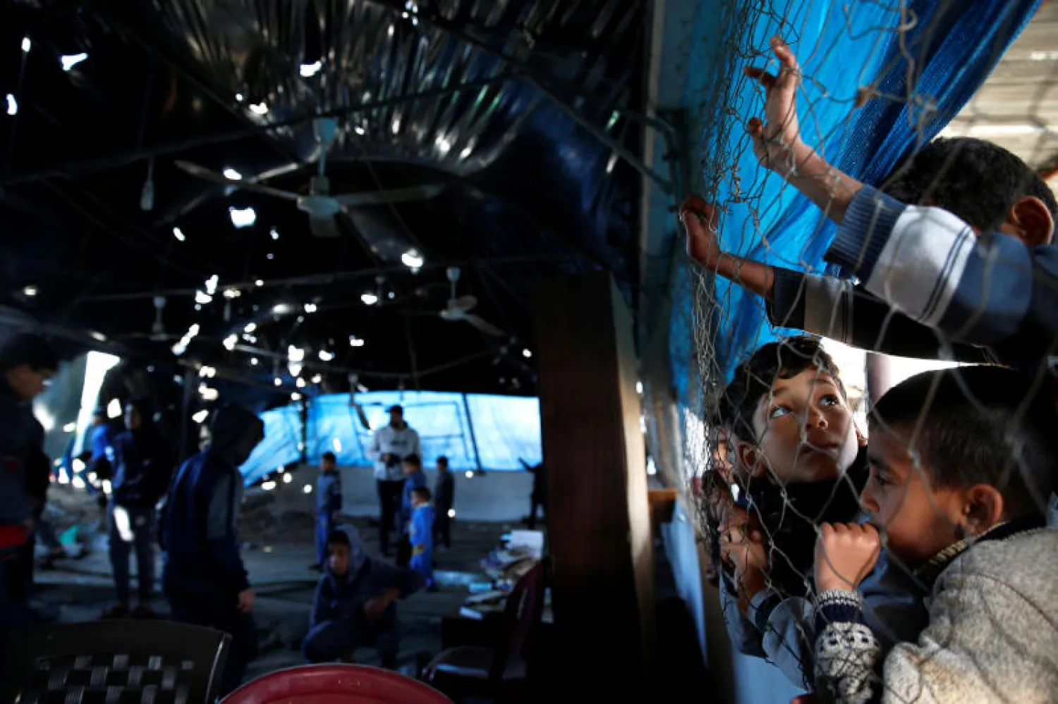 أولاد فلسطينيون يعاينون أضراراً لحقت بمسجد في غزة خلال القصف الإسرائيلي قبل أيام (رويترز)