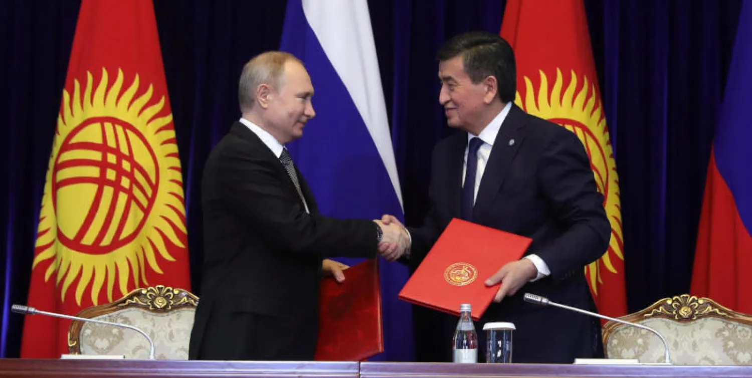 الرئيس الروسي فلاديمير بوتين يصافح نظيره القيرغيزي سورونباي جينبيكوف خلال حفل توقيع اتفاقية في بشكيك (رويترز)