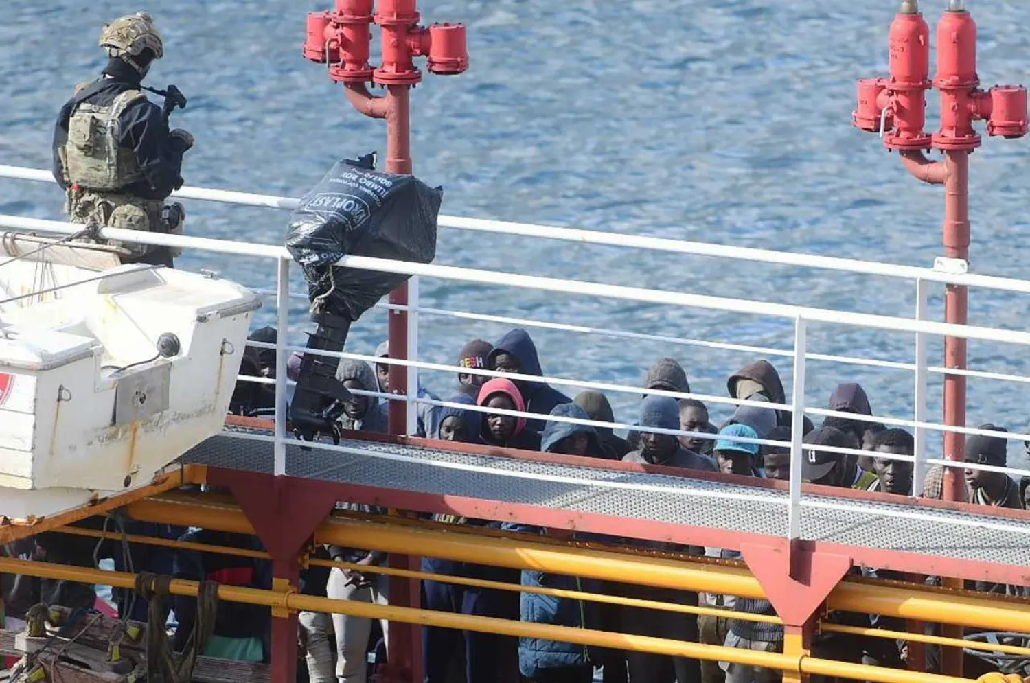 Army forces and migrants stand onboard Motor Tanker El Hiblu 1 that was hijacked by migrants it had rescued off Libya, docked at Boiler Wharf in Valletta's Grand Harbor on March 28, 2019, after Maltese armed forces took control of the vessel. (Photo by Matthew MIRABELLI / AFP)