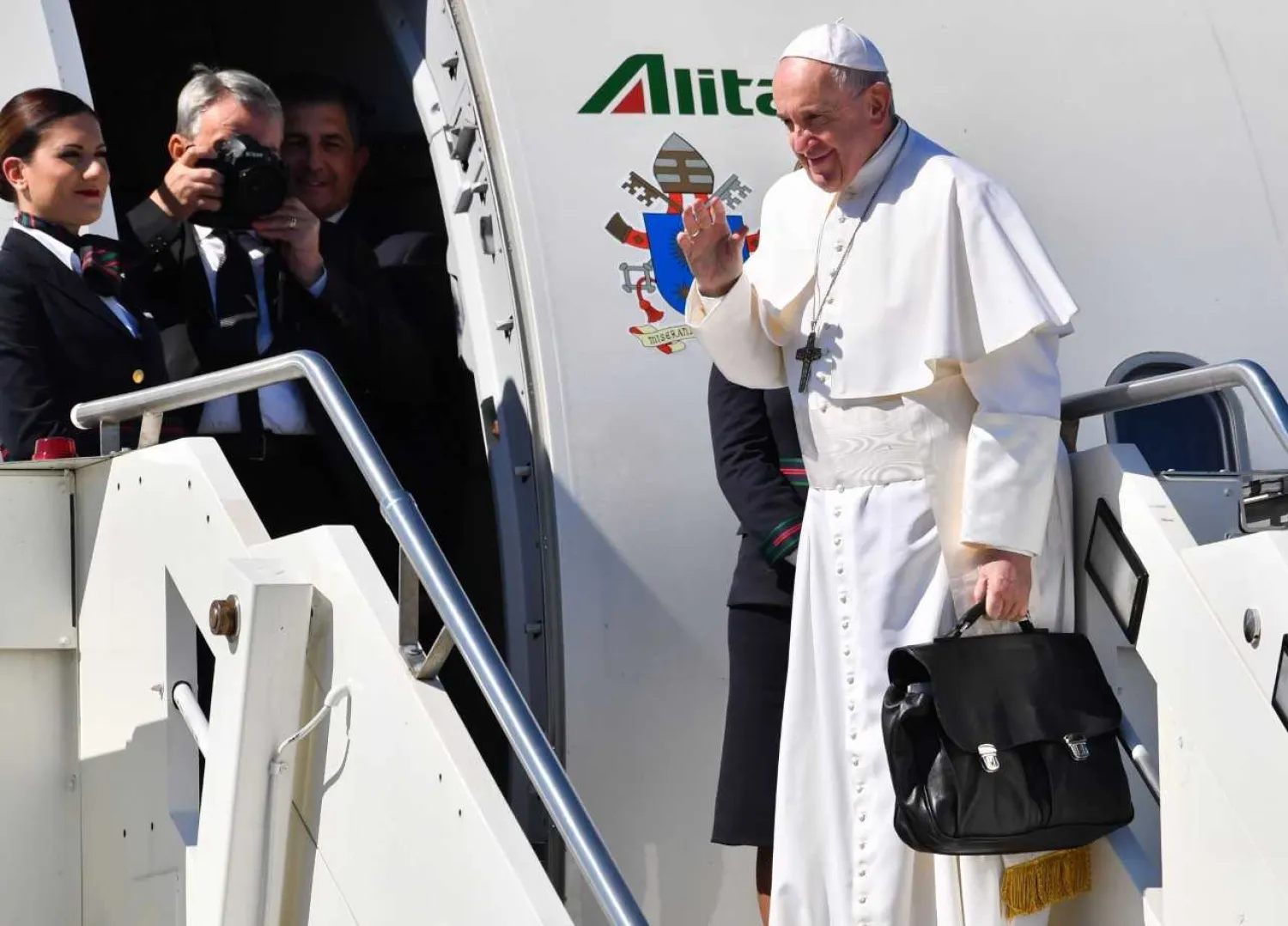 Pope Francis waves as he boards a plane upon his departure for a two-day trip to Morocco on March 30, 2019 at Rome's Fiumicino airport. (Photo by Andreas SOLARO / AFP)