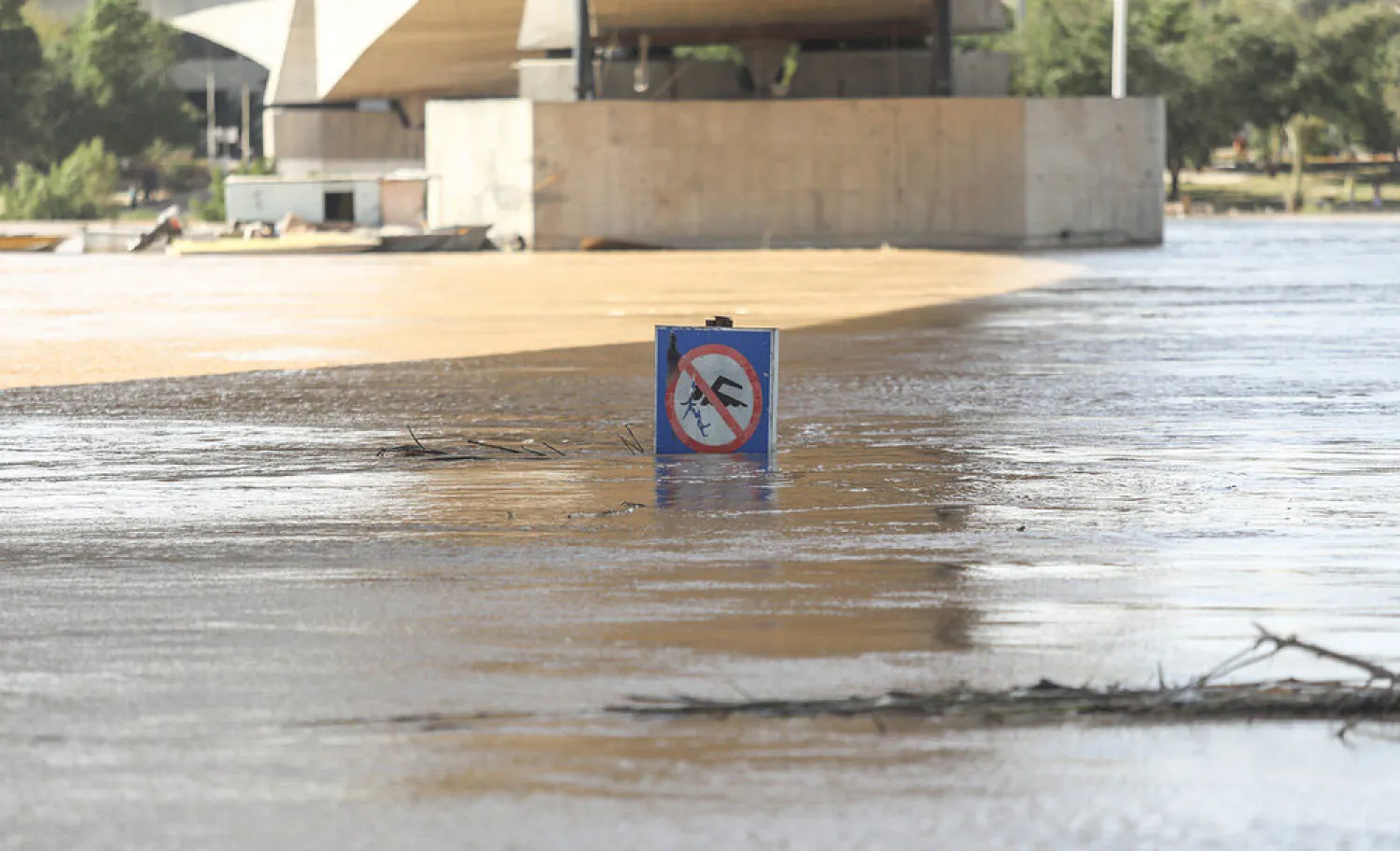 الفيضانات تغمر لوحة تحذر من الغرق في نهر كارون تحت أحد جسور مدينة الأحواز (وكالة مهر)