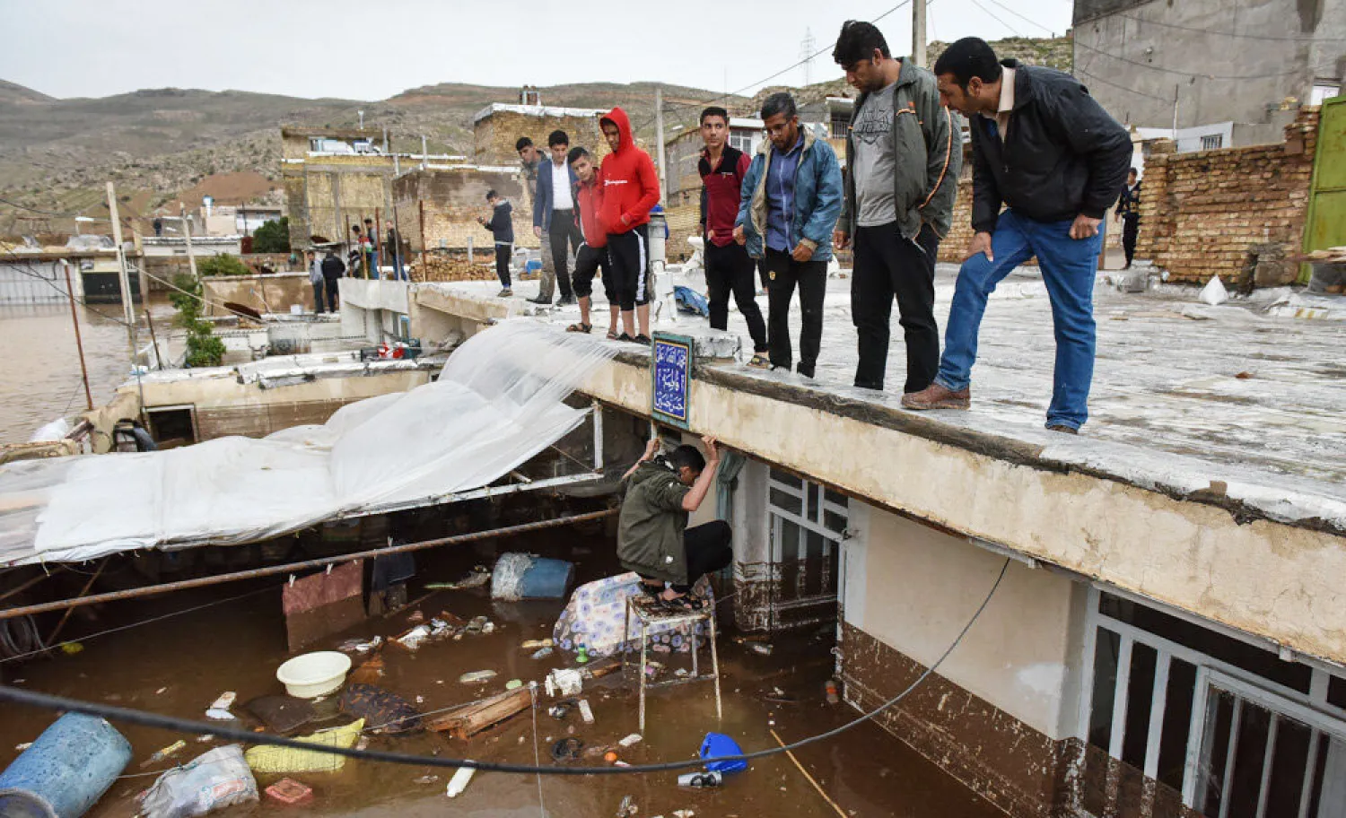 إيرانيون يتفقدون منازلهم بعد موجة فيضانات داهمت حي سعدي وسط شيراز (مهر)