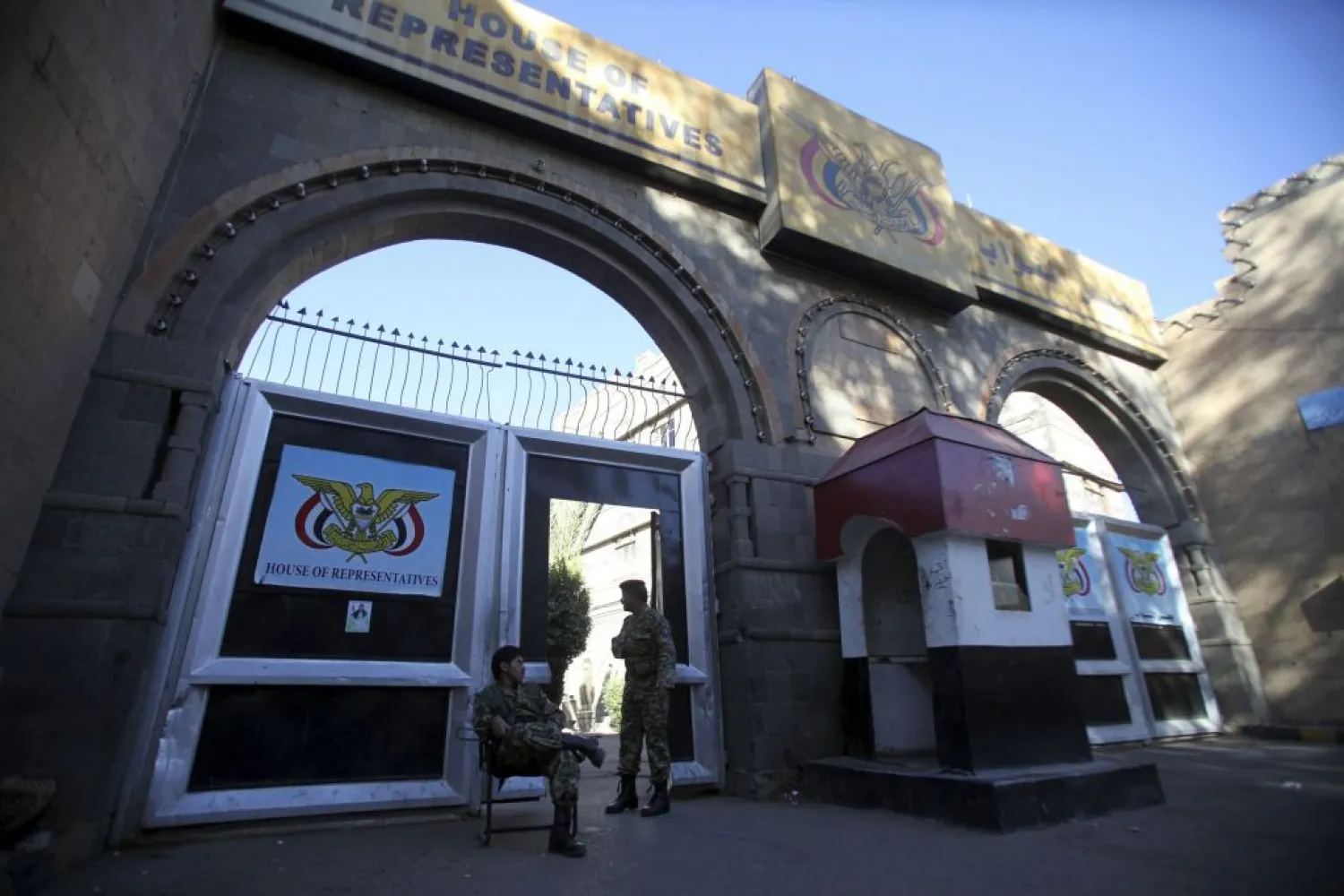 Houthis stand outside the parliament in Sanaa. (Reuters)