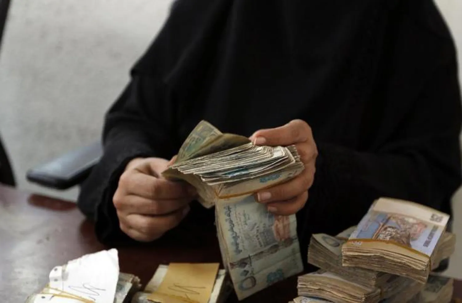 A Yemeni woman holds onto YER (AFP/FILE)

