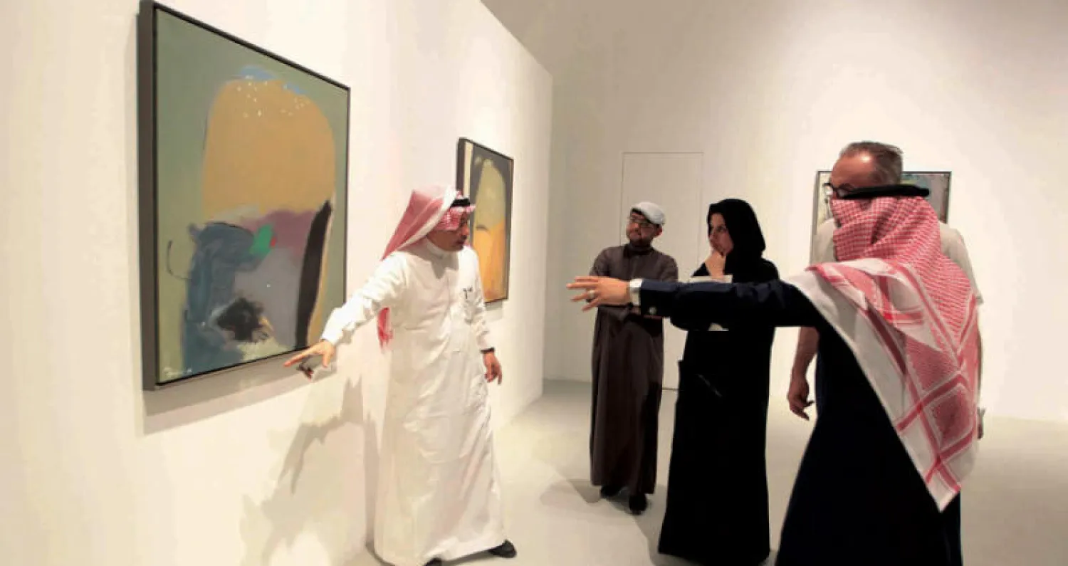 الفنان يوسف جاها يشرح أحد أعماله لزوار المعرض