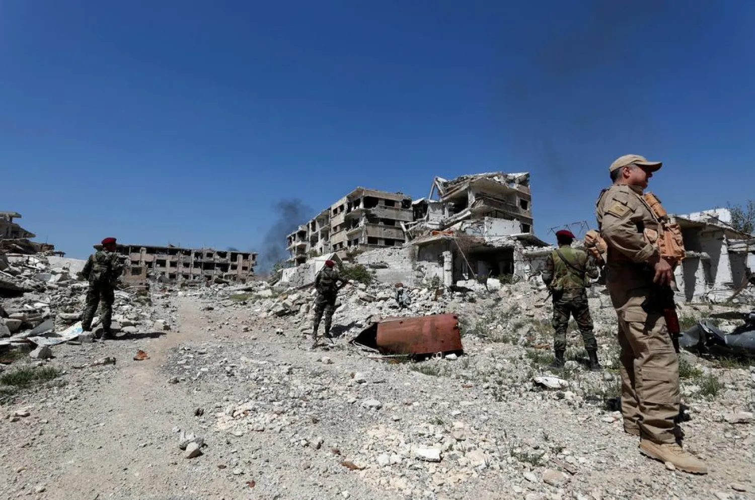 Syrian forces of Bashar al Assad stand guard near destroyed buildings in Jobar, eastern Ghouta, in Damascus, Syria April 2, 2018.
