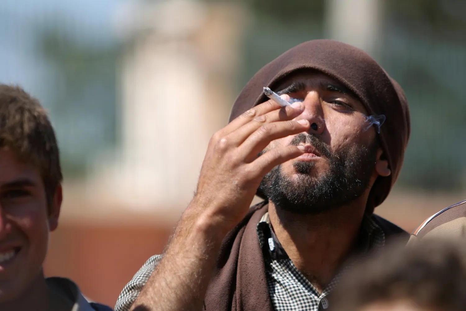 A man who fled Manbij city smokes a cigarette after arriving in the areas SDF forces seized on the outskirts of Manbij city, Aleppo province, Syria June 8, 2016. (Reuters)