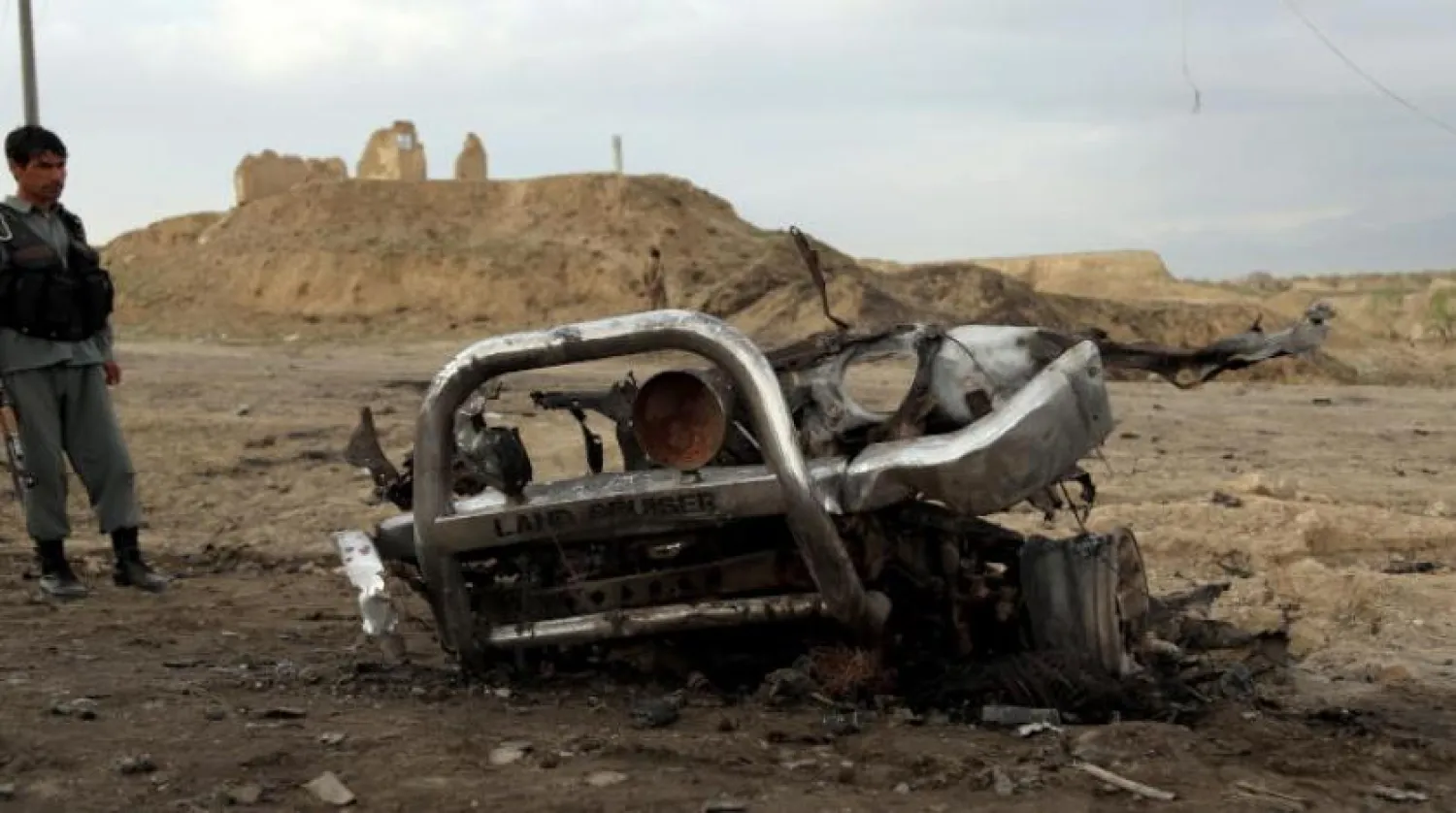 Bagram Hava Üssü yakınında patlayan bir aracın yanında duran Afgan askeri (EPA)
