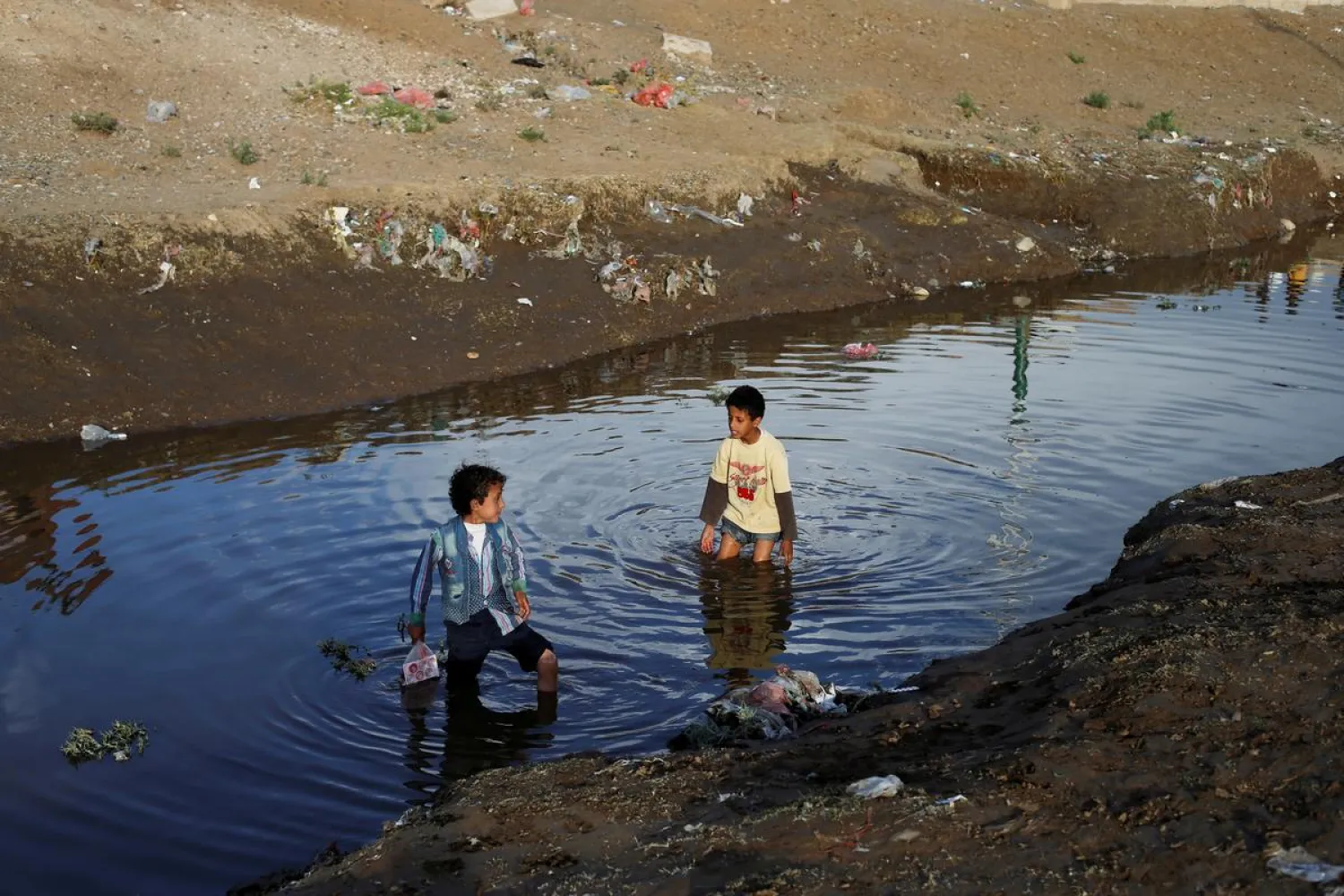 Children play in water at a sewage treatment pool amid an increase of cholera patients in Sanaa, Yemen March 17, 2019. (Reuters)