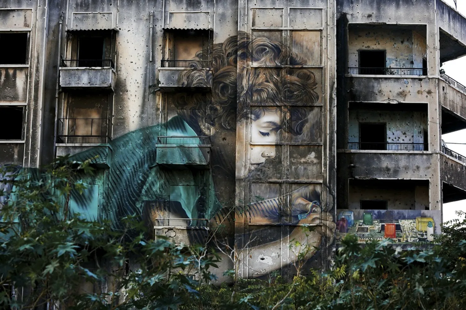 Graffiti by Cuban-American artist Jorge Rodriguez-Gerada depicting a boy is painted on a bullet riddled building on the former frontline of Lebanese civil war in downtown Beirut. (AP)