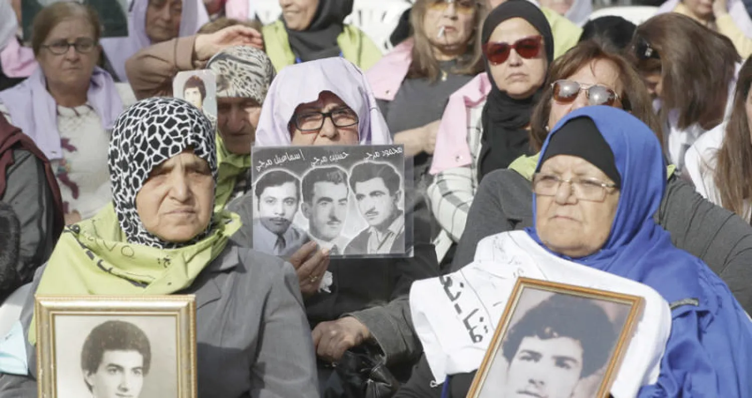 أهالي المفقودين في الحرب يحملون صور ذويهم في تجمع وسط بيروت أمس (أ.ف.ب)