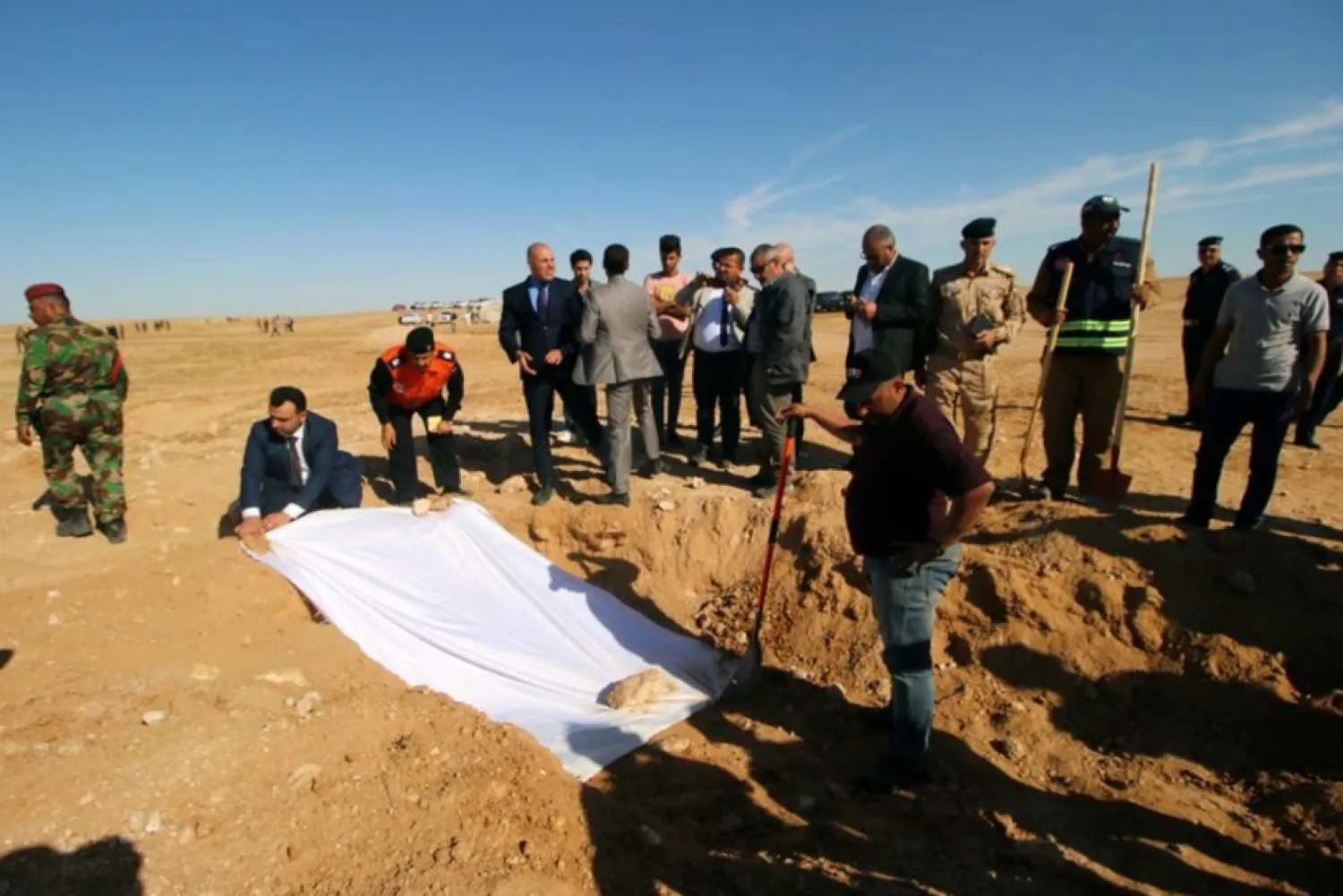Iraqi members of the Civil Defense cover the bones from an unearthed mass grave of Kurds in west of the city of Samawa, Iraq April 14, 2019. REUTERS/Essam al-Sudani