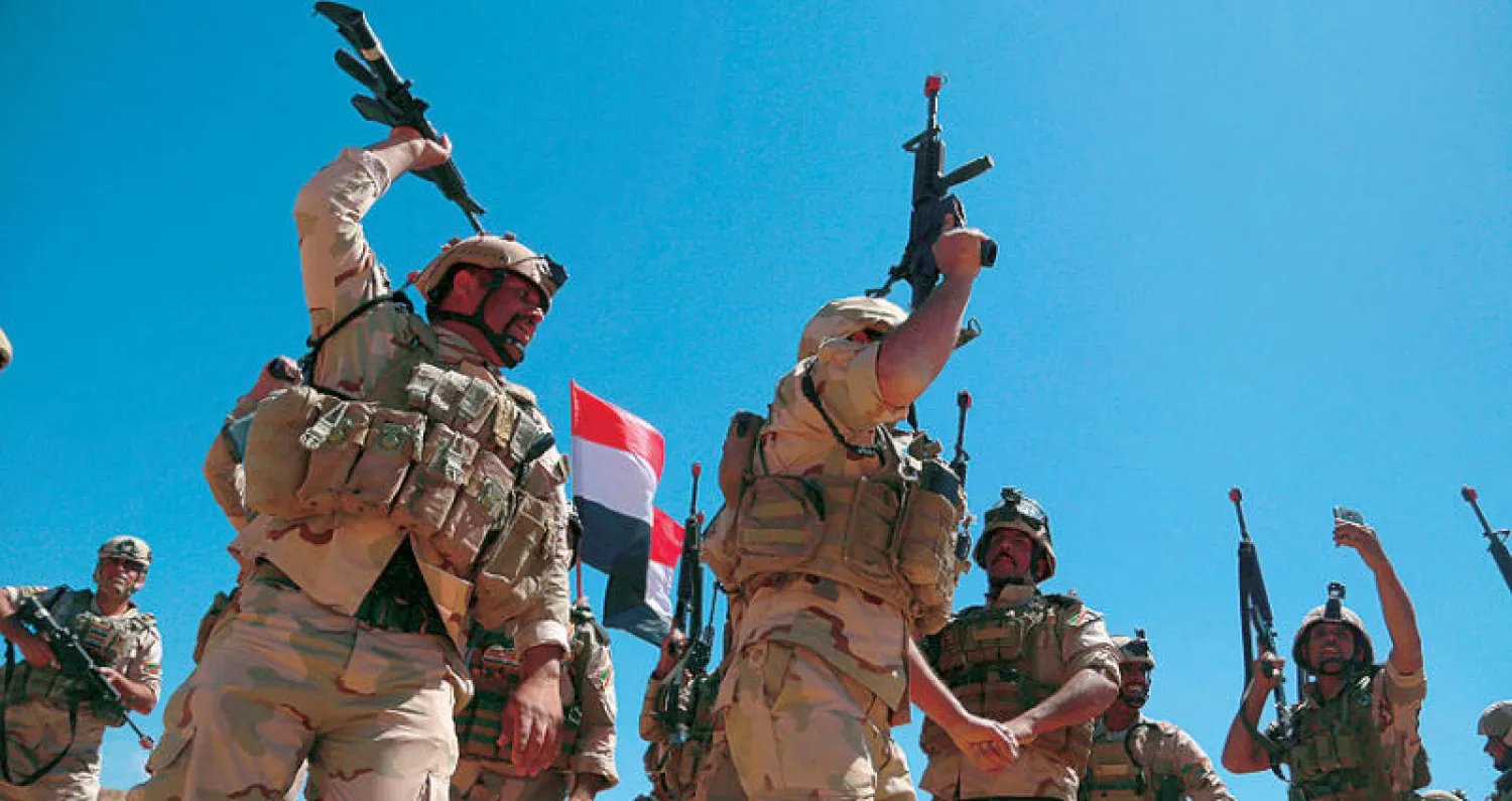 جنود عراقيون يهتفون ضد «داعش» خلال تدريب مشترك مع قوات أسترالية ونيوزيلندية  في قاعدة التاجي شمال بغداد أمس (أ.ب)