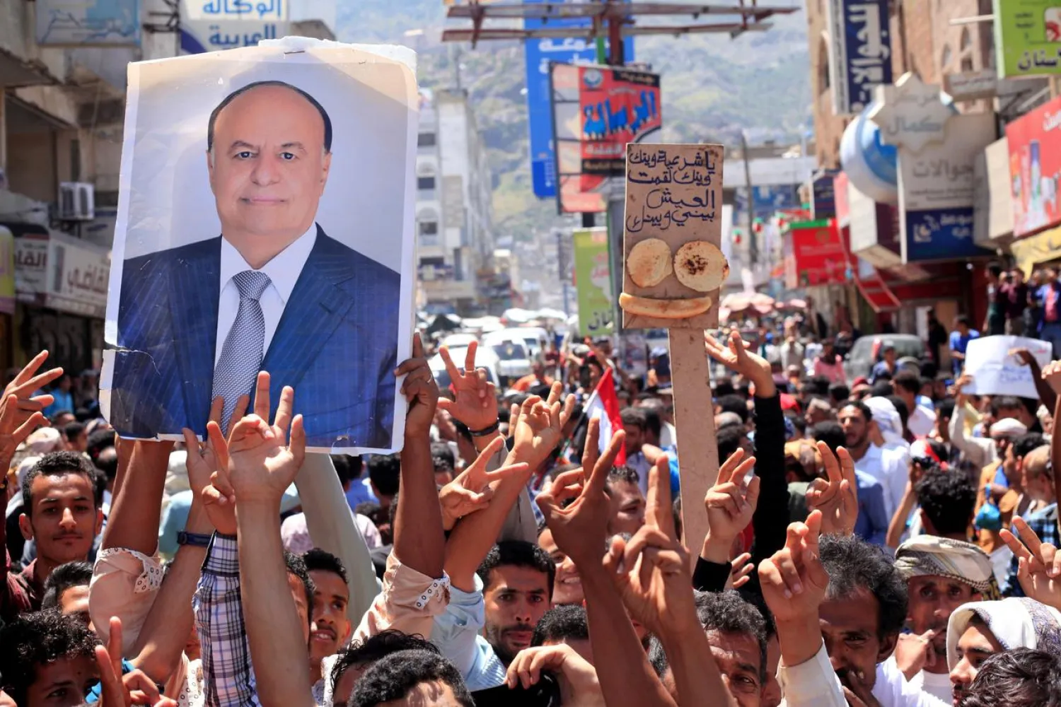Protesters hold up a poster of Yemeni President Abdrabbuh Mansur Hadi during a rally in Taiz, Yemen, October 4, 2018. (Reuters)