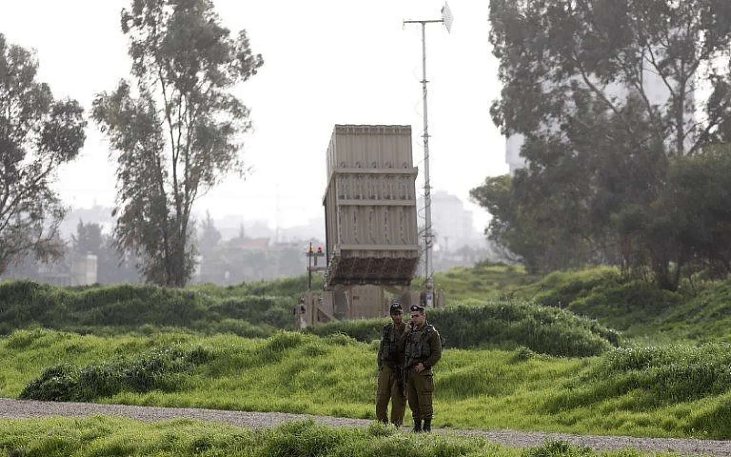  Illustrative. Israeli soldiers stand near a battery of the Iron Dome missile defense system deployed in Tel Aviv on January 24, 2019. (Menahem Kahana/AFP)