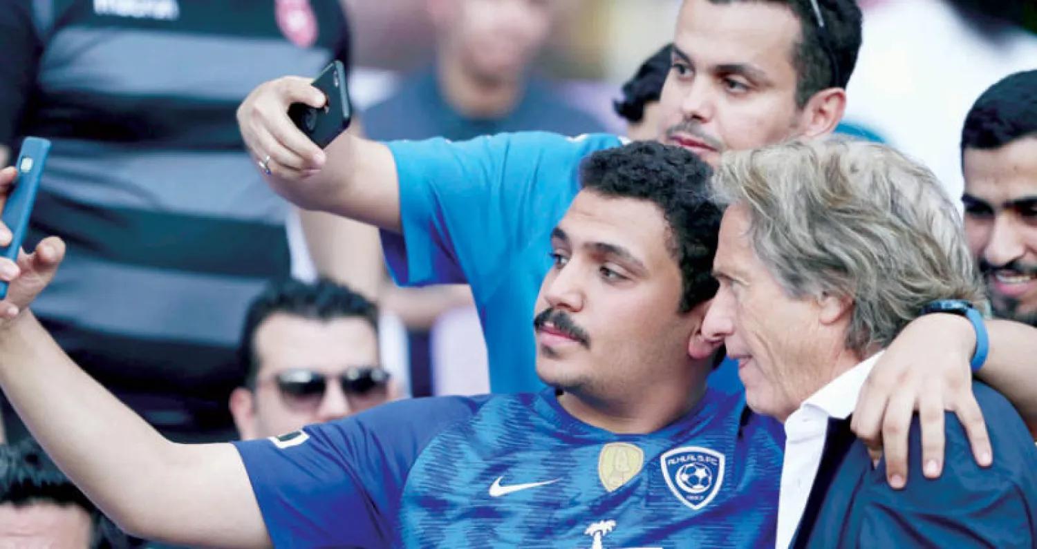 مشجع هلالي يلتقط صورة مع المدرب السابق للفريق خيسوس خلال النهائي العربي أول من أمس (تصوير: بشير صالح)