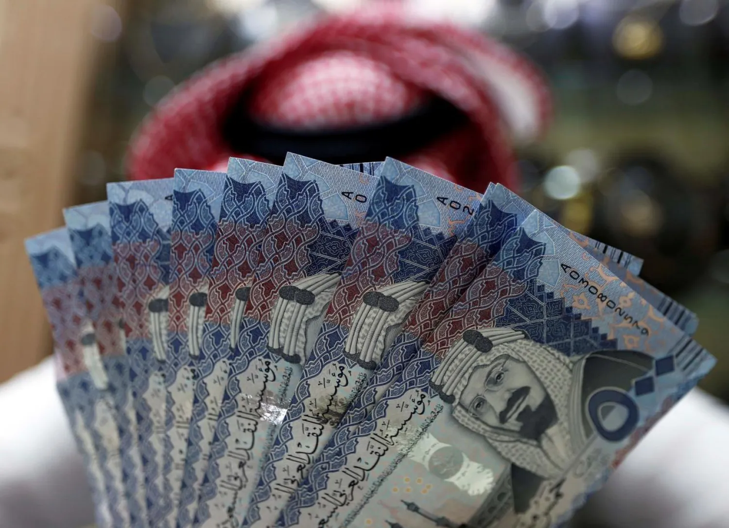 Saudi money changer displays Saudi banknotes at a currency exchange shop in Riyadh, Saudi Arabia (Reuters)