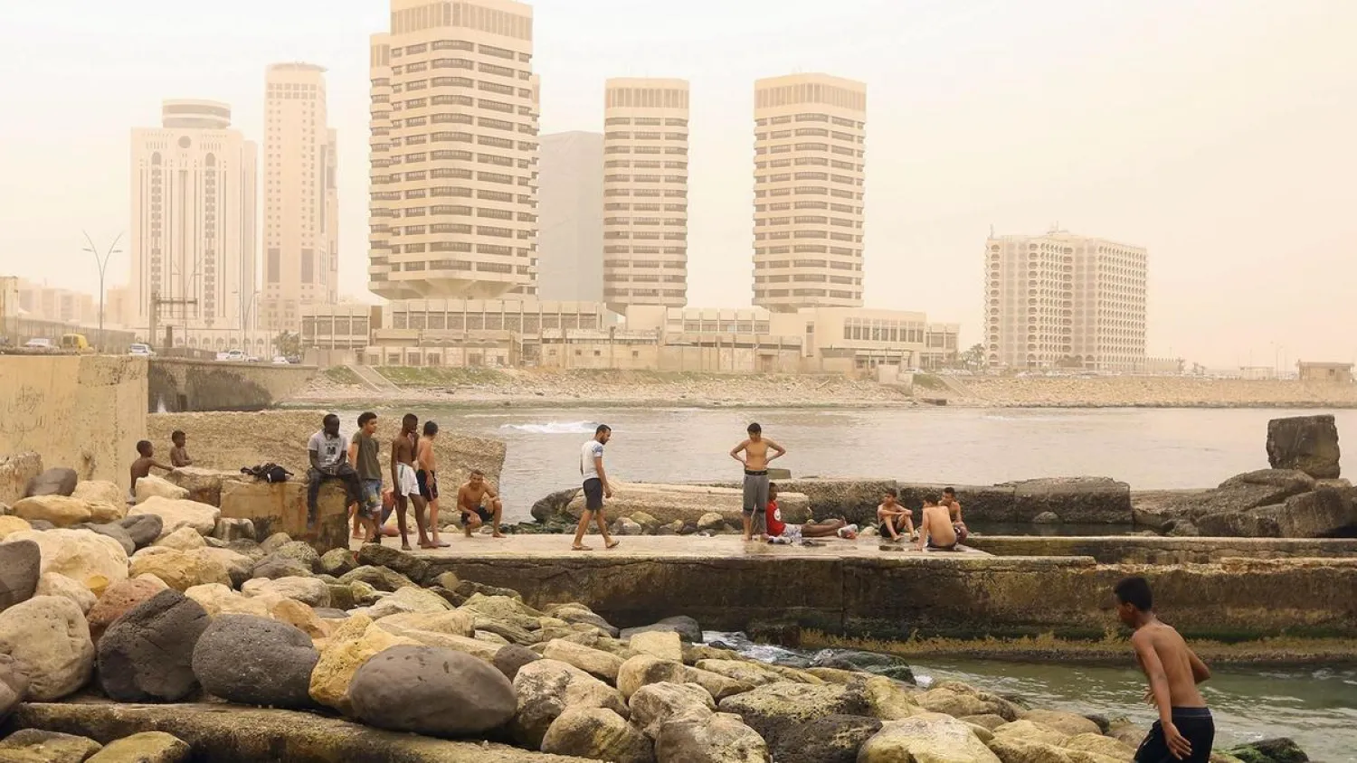 Libyan children gather on the beach near the main port of Tripoli, Libya on April 22, 2019. Mahmud TURKIA / AFP