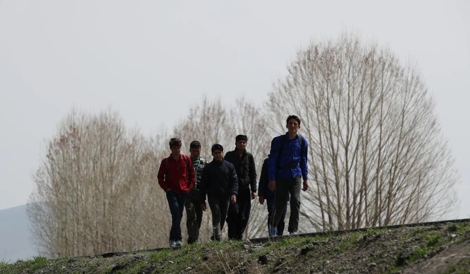 A group of Afghan migrants walk along a main road after crossing the Turkey- Iran border near Erzurum, eastern Turkey, April 12, 2018. (Reuters)