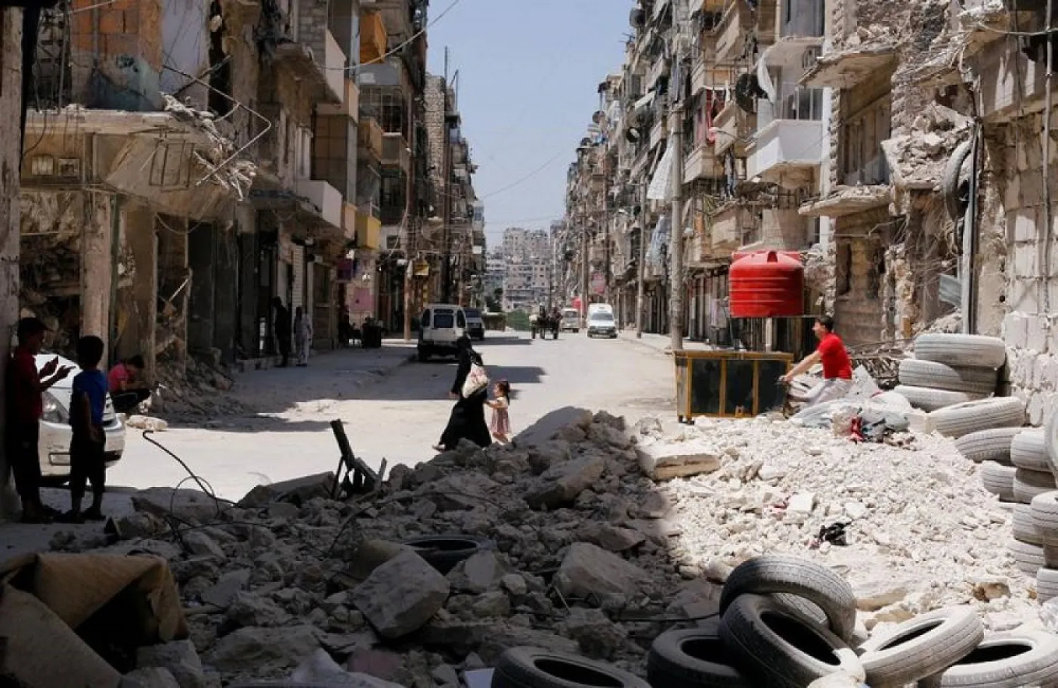 A woman walks with a child amid rubble at Bustan al-Qasr neighborhood in Aleppo, Syria July 16, 2017. (Reuters)