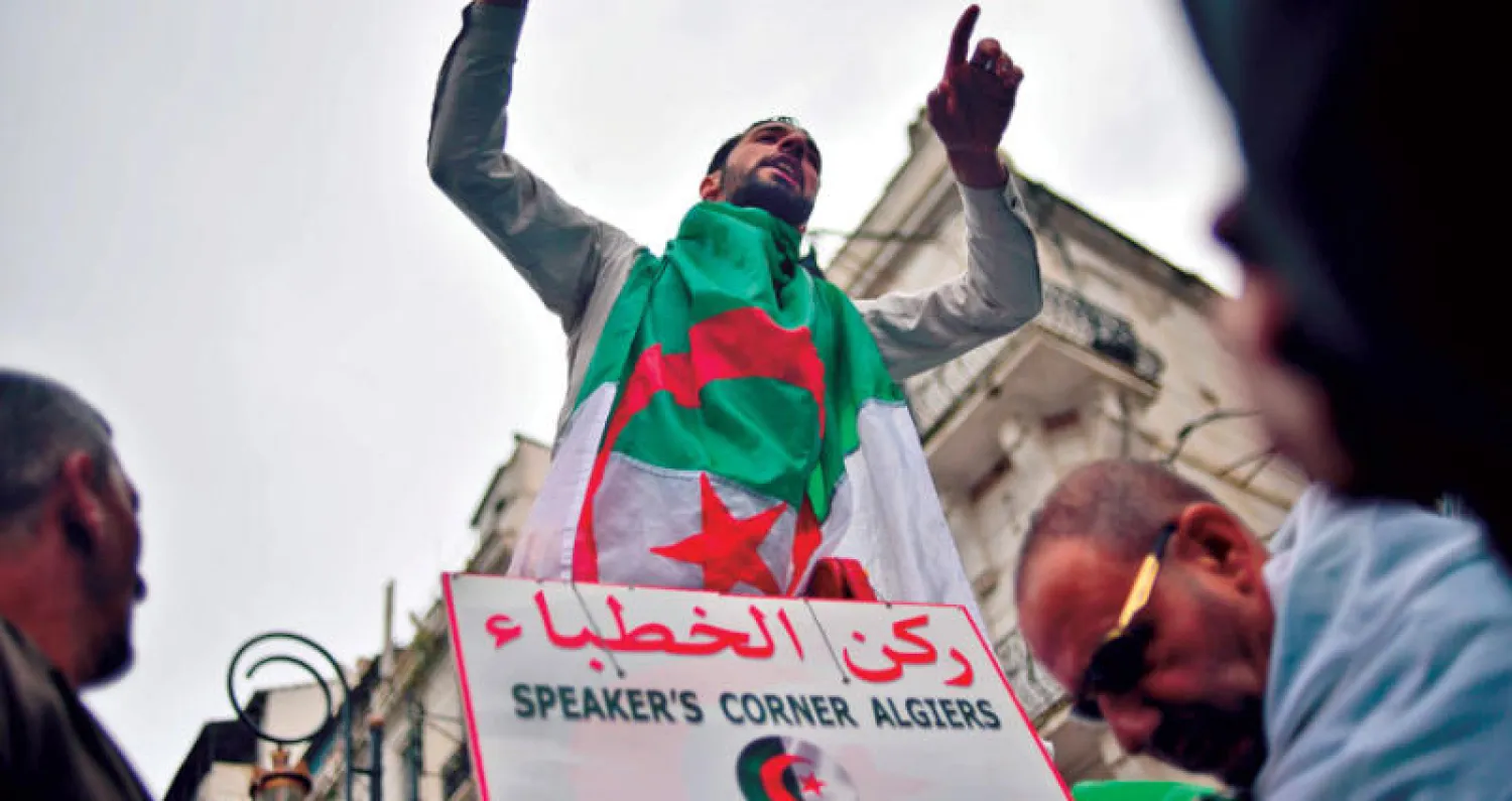 جزائري يعبر عن رأيه بحرية فوق منبر الخطباء وسط العاصمة الجزائرية (أ.ف.ب)