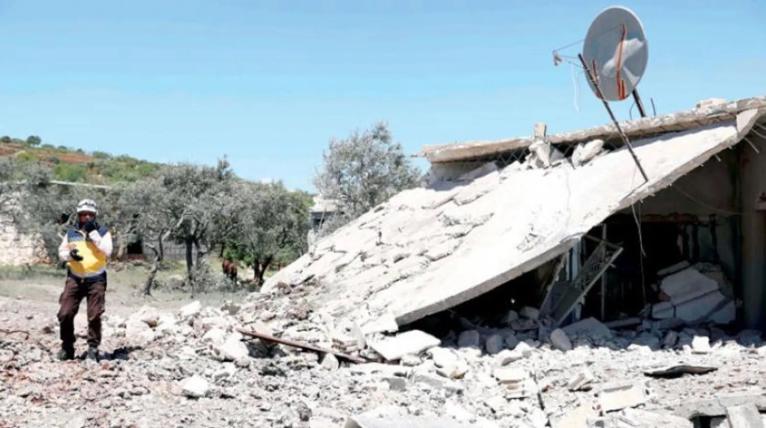 4 Mayıs’ta İdlib kırsalına yönelik bir bombardımanda yıkılan bir evin yakınındaki sivil savunma unsuru (AFP)