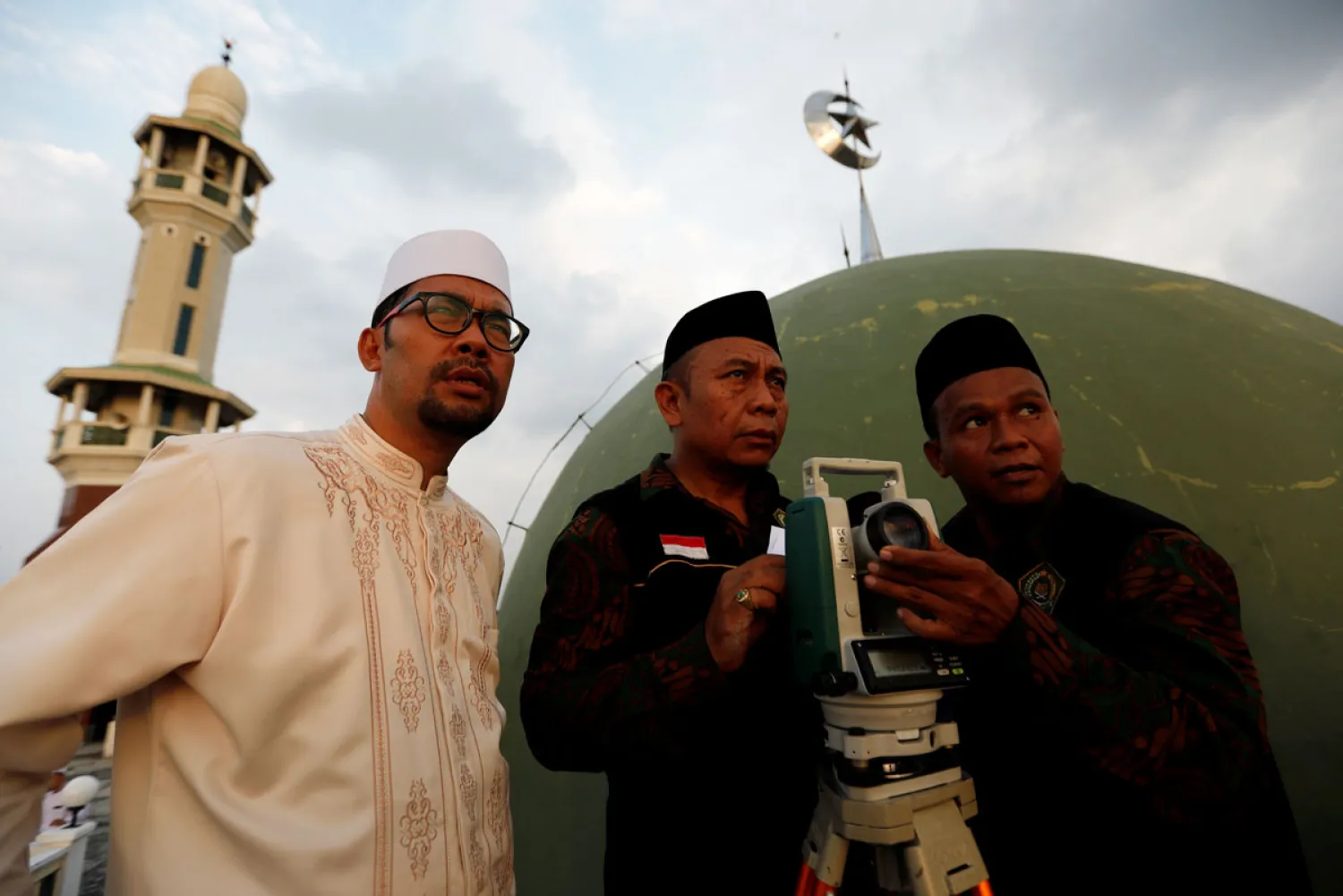 رجال خلف جهاز الثيودوليت لاستطلاع هلال شهر رمضان في إندونيسيا (رويترز) 