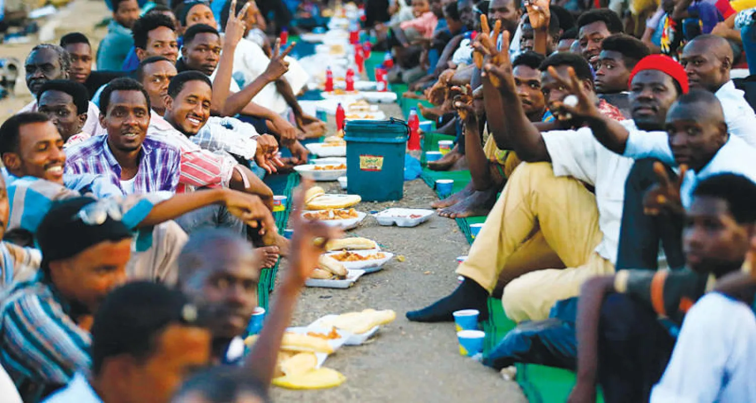 معتصمون خلال إفطار جماعي أمام مقر وزارة الدفاع في الخرطوم (أ.ف.ب)