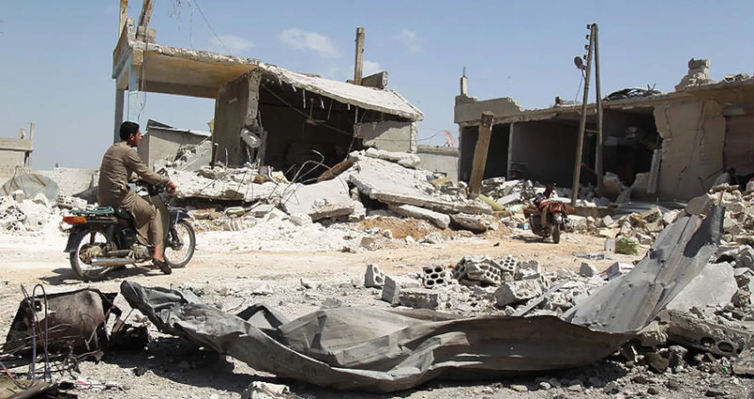 على الدراجة وسط الدمار في سراقب جراء القصف الروسي والسوري أمس (أ.ف.ب)