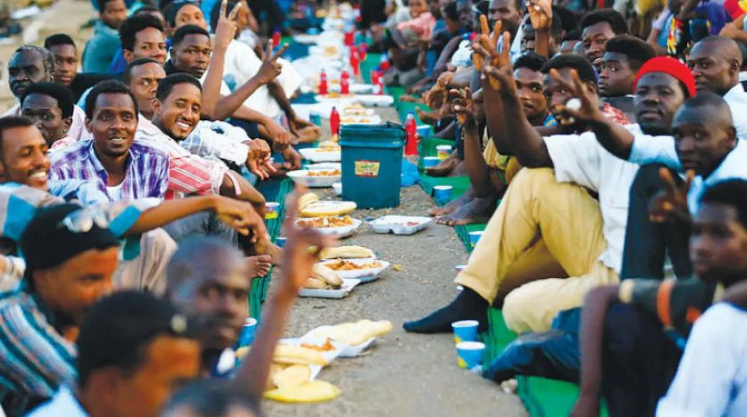 Sudanlı protestocular Hartum'daki Savunma Bakanlığı karargahının önünde iftar yaptıkları sırada (AFP)