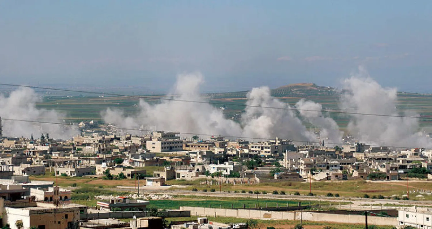 دخان يتصاعد من خان شيخون بعد القصف الروسي والسوري أمس (أ.ف.ب)