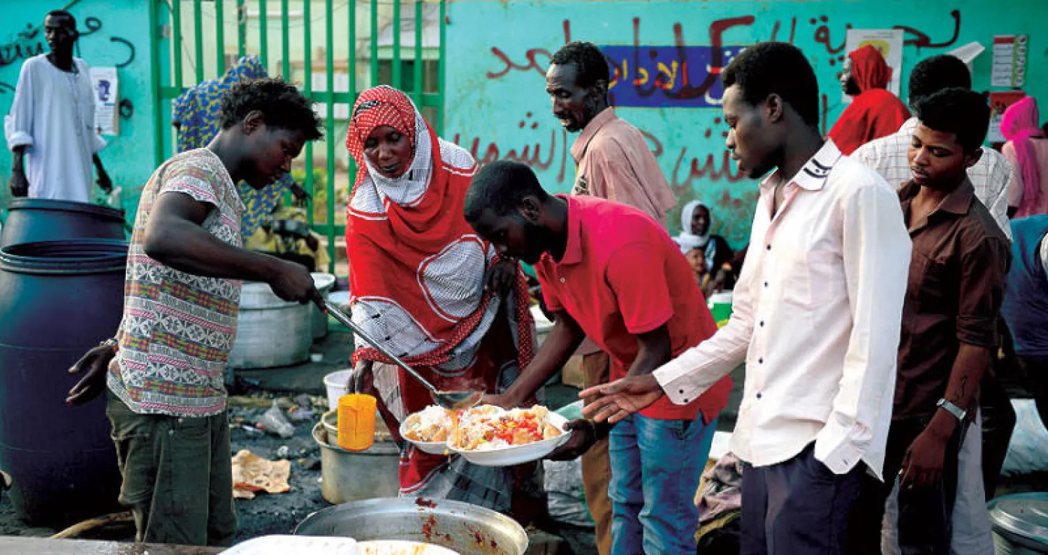 سوداني يقدم افطارا للمعتصمين امام قيادة الجيش في الخرطوم (أ.ف.ب)