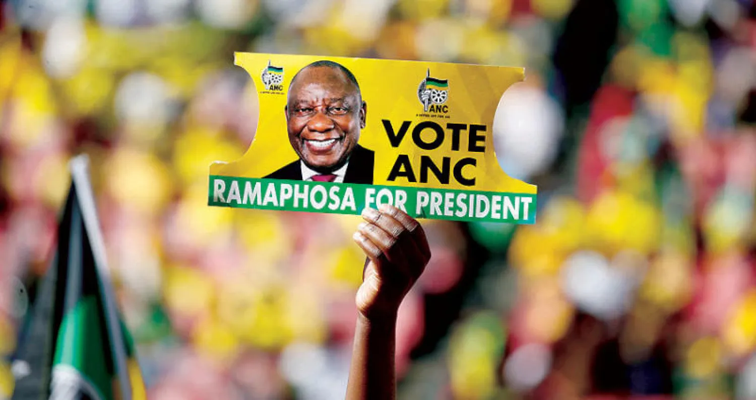 أحد أنصار الرئيس رامافوزا يحمل لافتة حزبه في فعالية انتخابية بجوهانسبيرغ الأسبوع الماضي (رويترز)