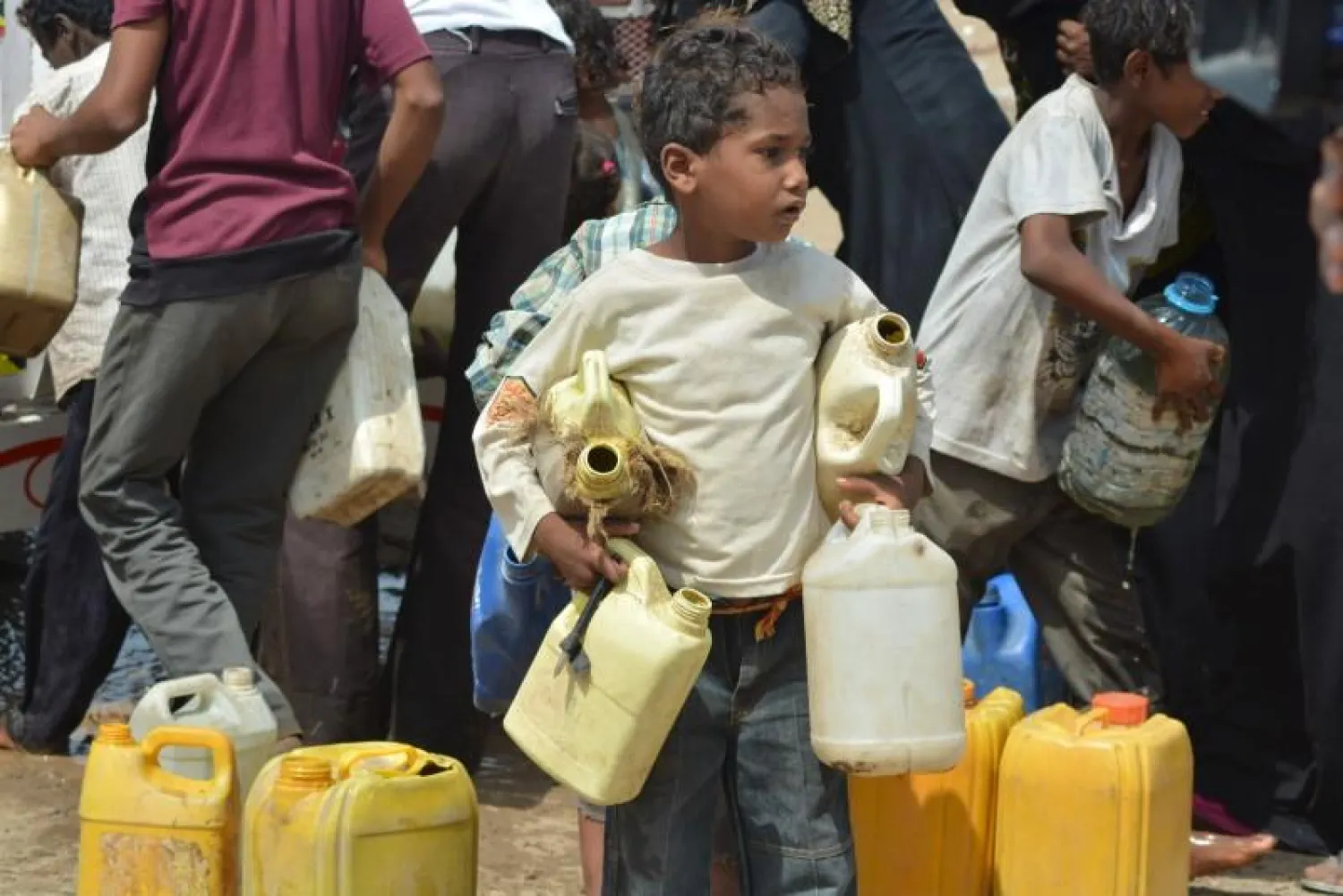 A boy carries jerrycans to fill from a water tanker truck in a slum neighborhood in Yemen's Red Sea city of Hodeidah February 15, 2016. (Reuters)