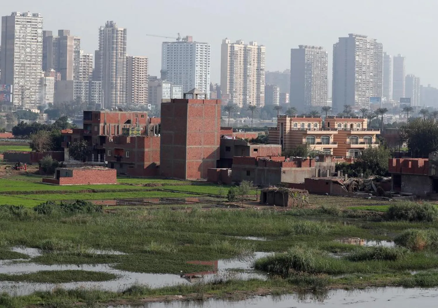 A view of houses and farmland on an island on the River Nile in front of high-rise buildings in Cairo, Egypt, November 25, 2018. REUTERS/Amr Abdallah Dalsh
