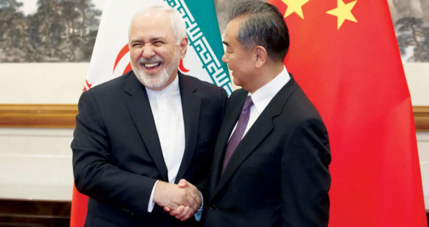 عضو مجلس الدولة الصيني وانغ يي مع وزير خارجية إيران محمد جواد ظريف في بكين أمس (أ.ف.ب)