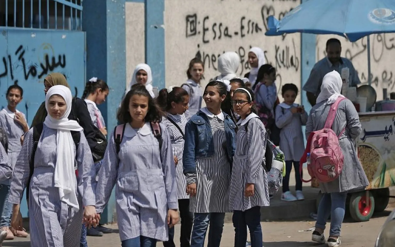 Pupils gather in front of a school run by the United Nations Agency for Palestinian Refugees (UNRWA) in Gaza City on August 29, 2018, on the first day of classes after the summer holidays. (AFP/ Mahmud Hams)