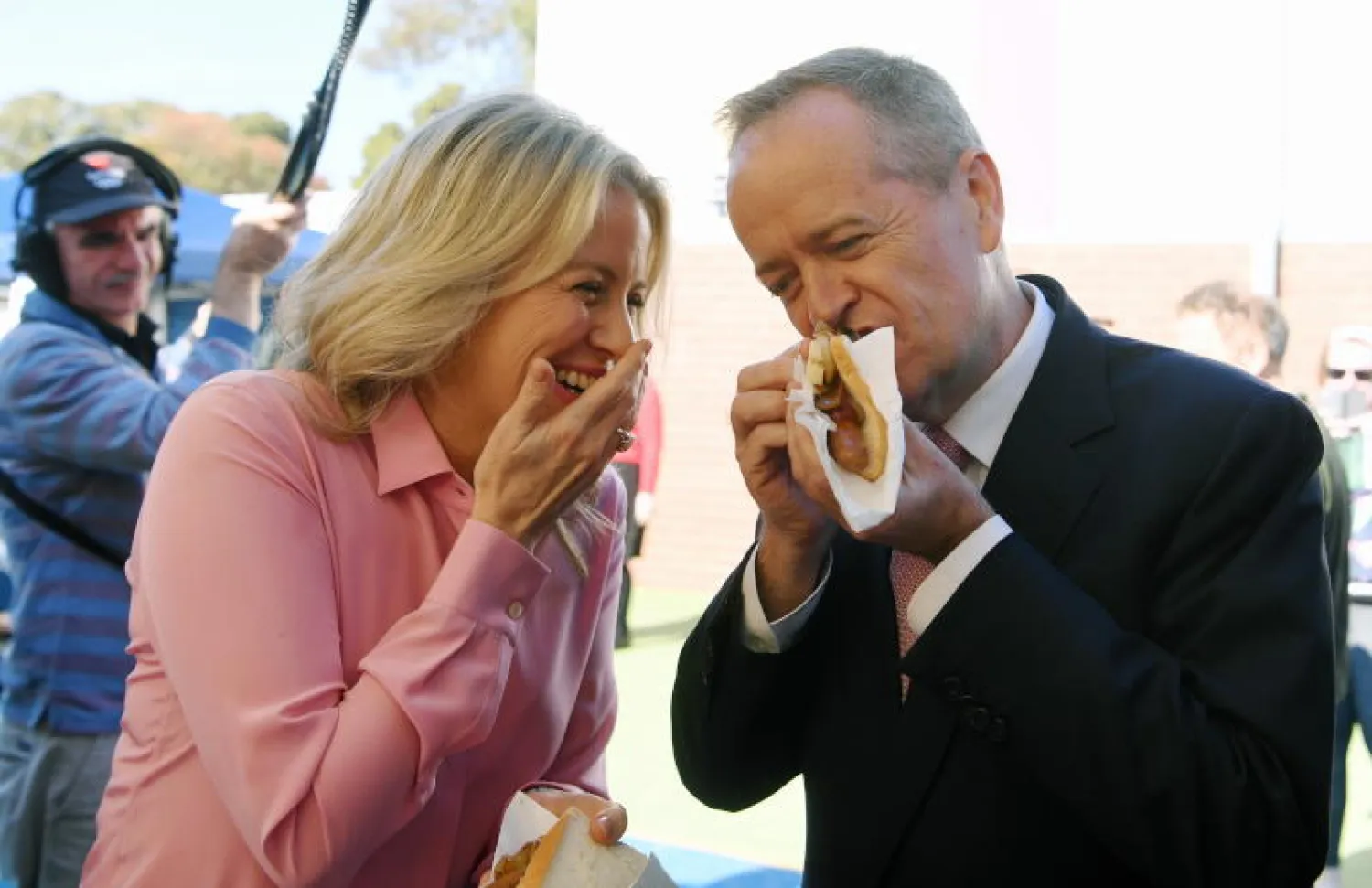 زعيم المعارضة الأسترالية بيل شورتن وزوجته كلوي يأكلان نقانق الديمقراطية بعد الإدلاء بصوتيهما في ملبورن (إ.ب.أ)