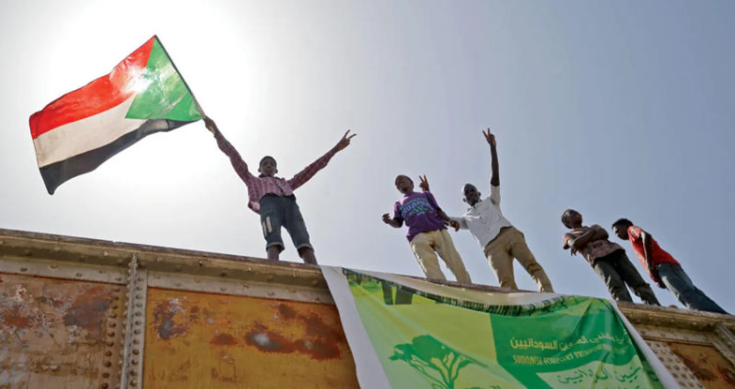 محتجون على أحد الجسور في ميدان الاعتصام بالخرطوم (أ.ف.ب)