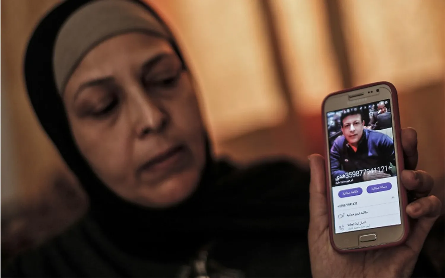 The sister of Zaki Mubarak shows his picture during an interview in their family home in Gaza on April 30. (AFP)