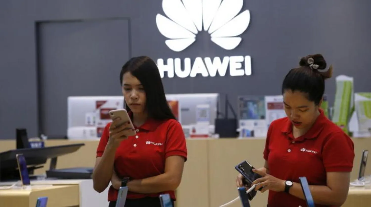 Bangkok’ta bulunan bir Huawei mağazasındaki iki çalışan (EPA)
